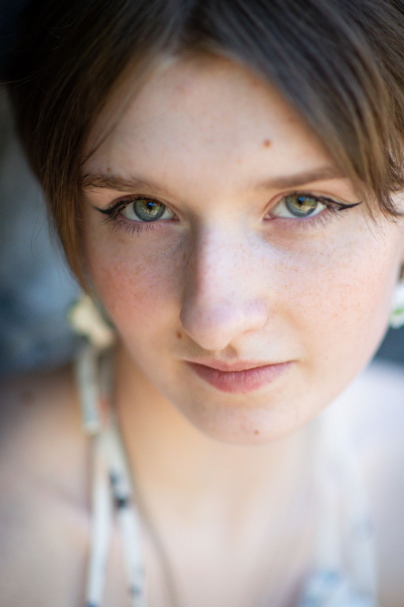 Close-up portrait of a freckled teenage girl looking toward the camera in Chilliwack, British Columbia.