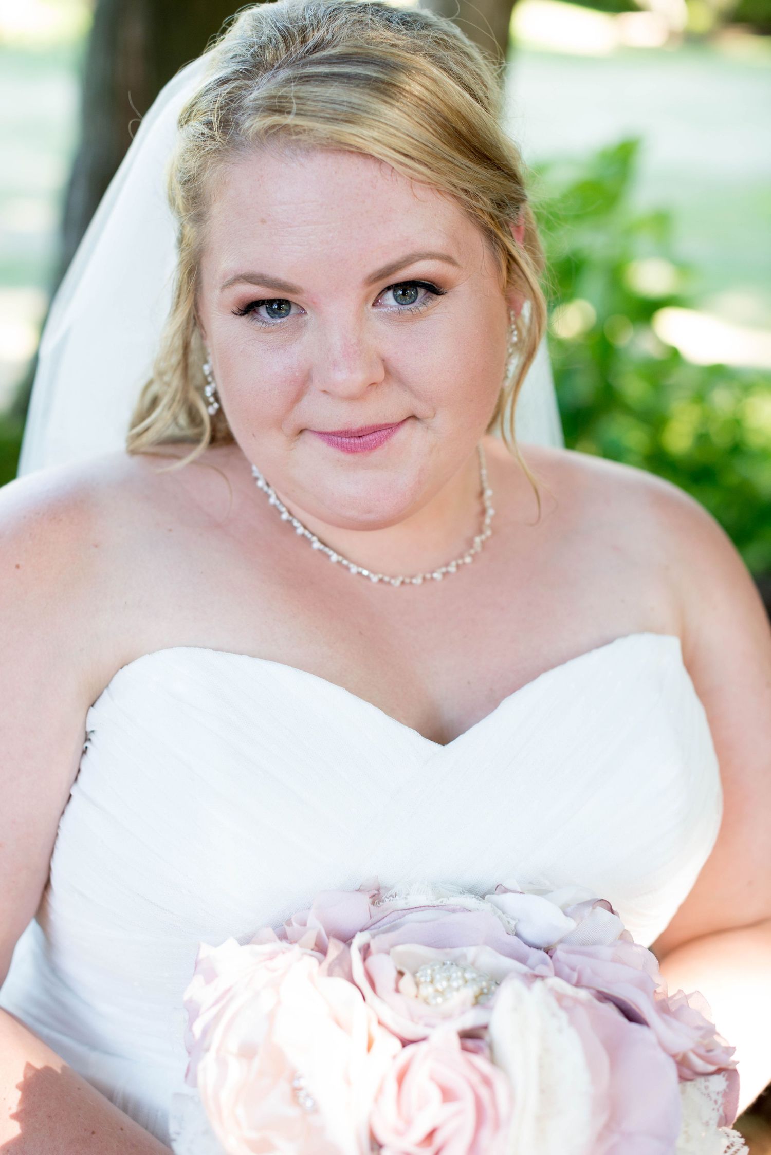 Bridal portrait of a smiling bride holding a pink bouquet in Chilliwack, British Columbia.