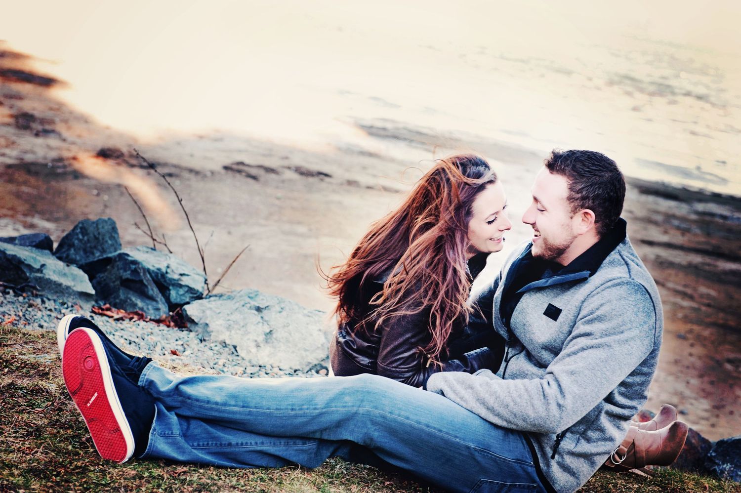 Couple sharing a quiet moment on the shoreline of Harrison Lake, British Columbia, during an engagement session.