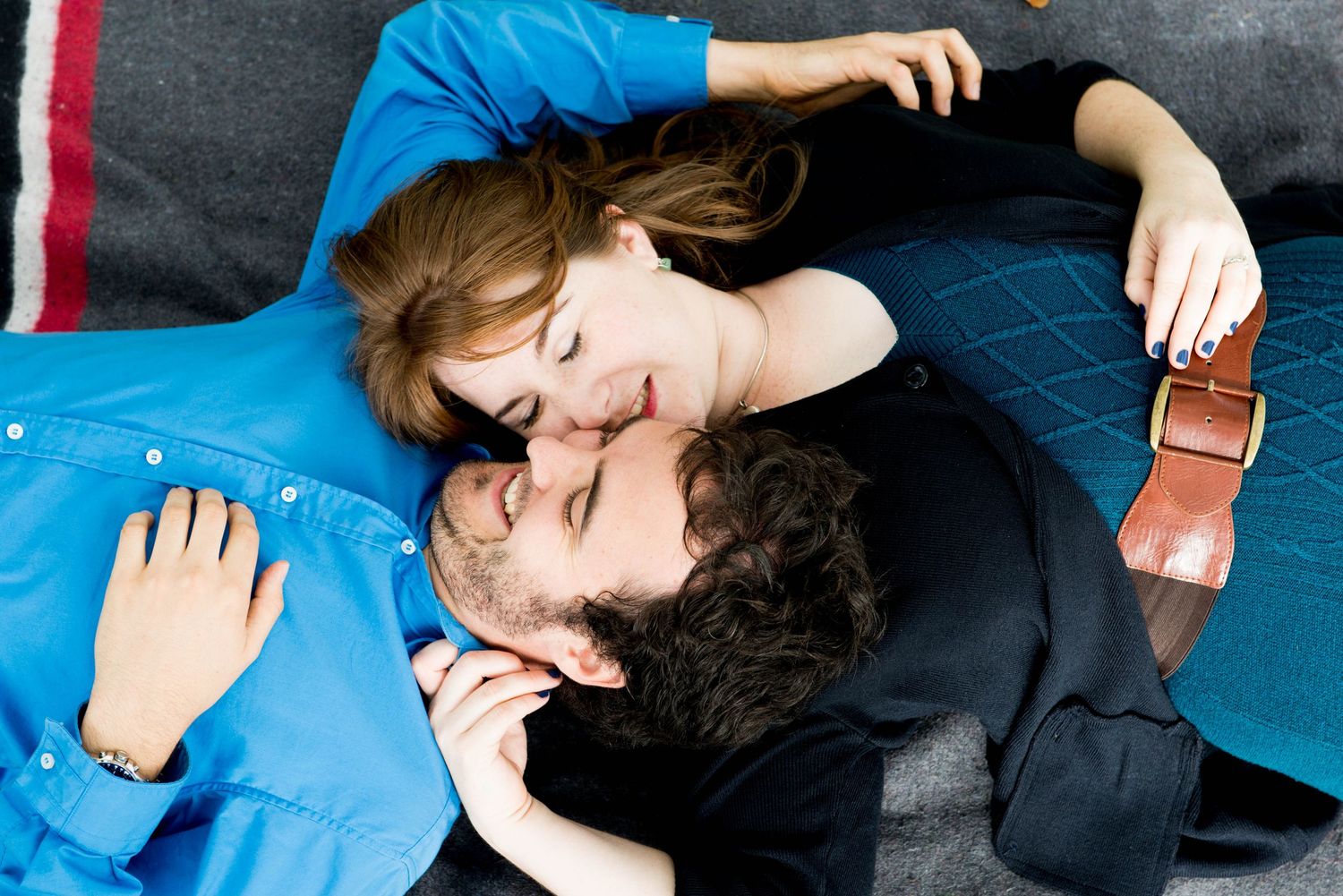 Couple relaxing together on a picnic blanket during an indoor engagement session in Burnaby, British Columbia.