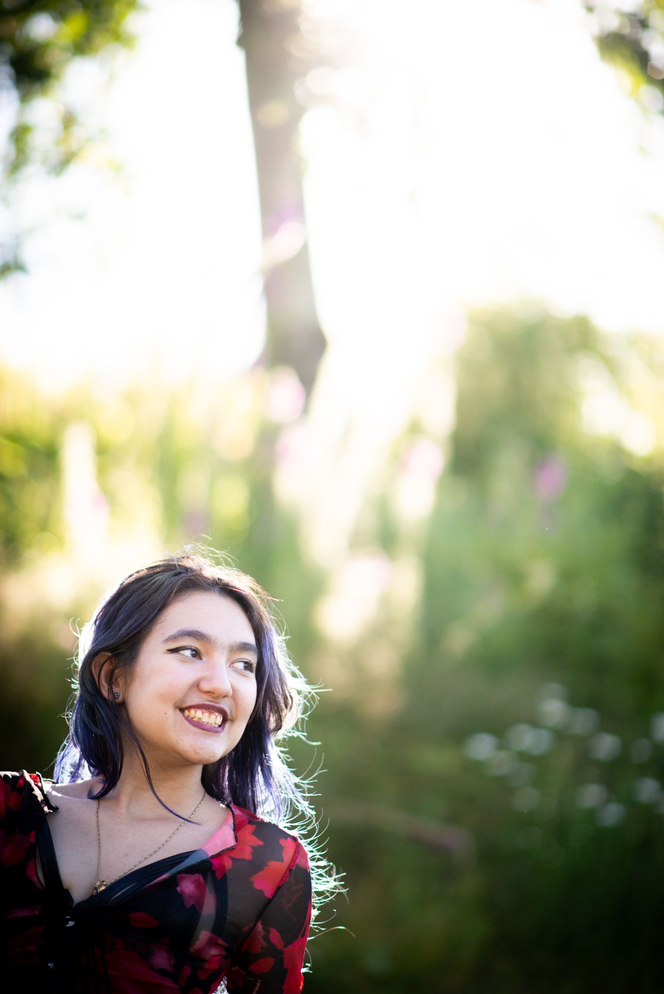 Graduation portrait of a smiling young woman in a sunlit garden in Chilliwack, British Columbia.