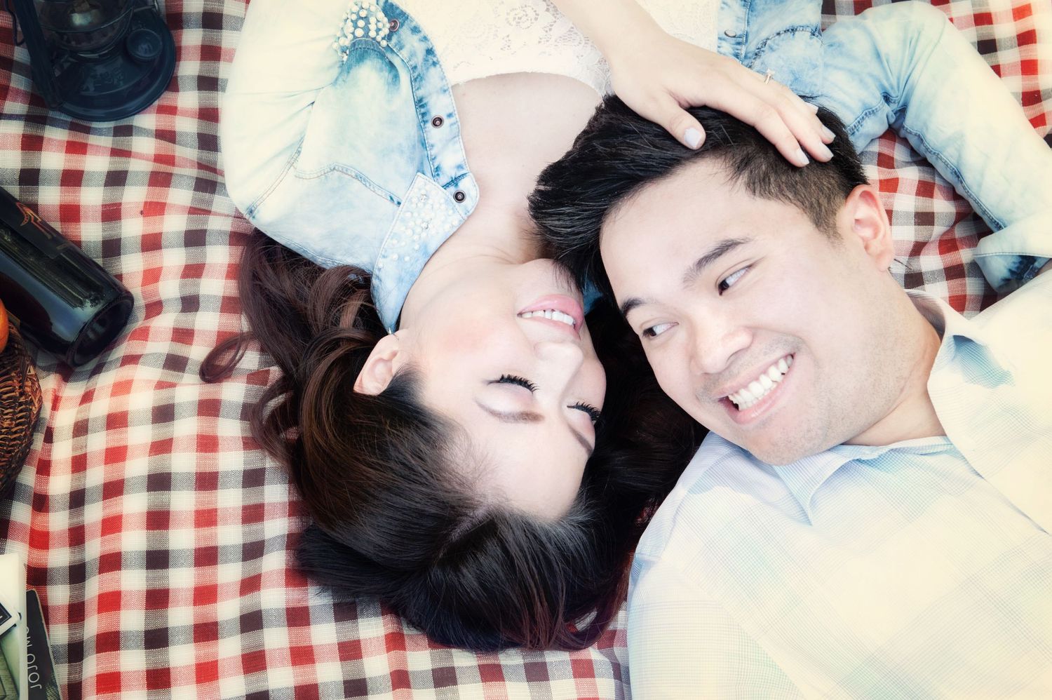 Couple relaxing together on a picnic blanket during an engagement session in Burnaby, British Columbia.