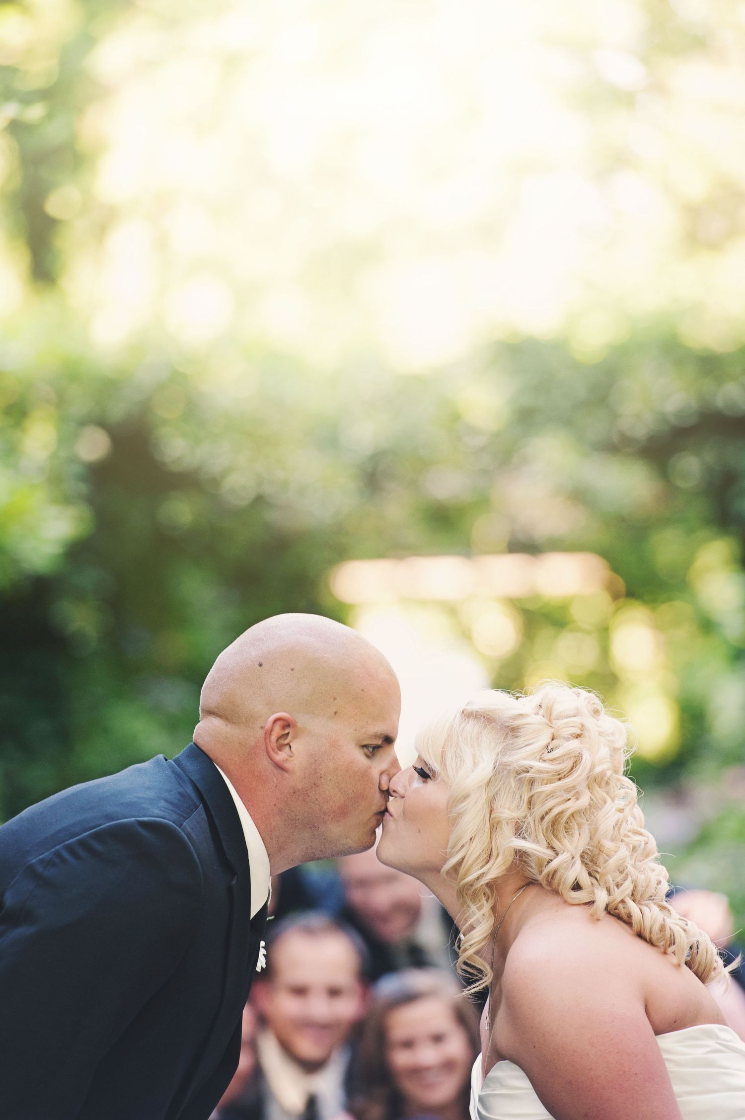 Bride and groom sharing their first kiss during an outdoor wedding ceremony at Minter Gardens in British Columbia.