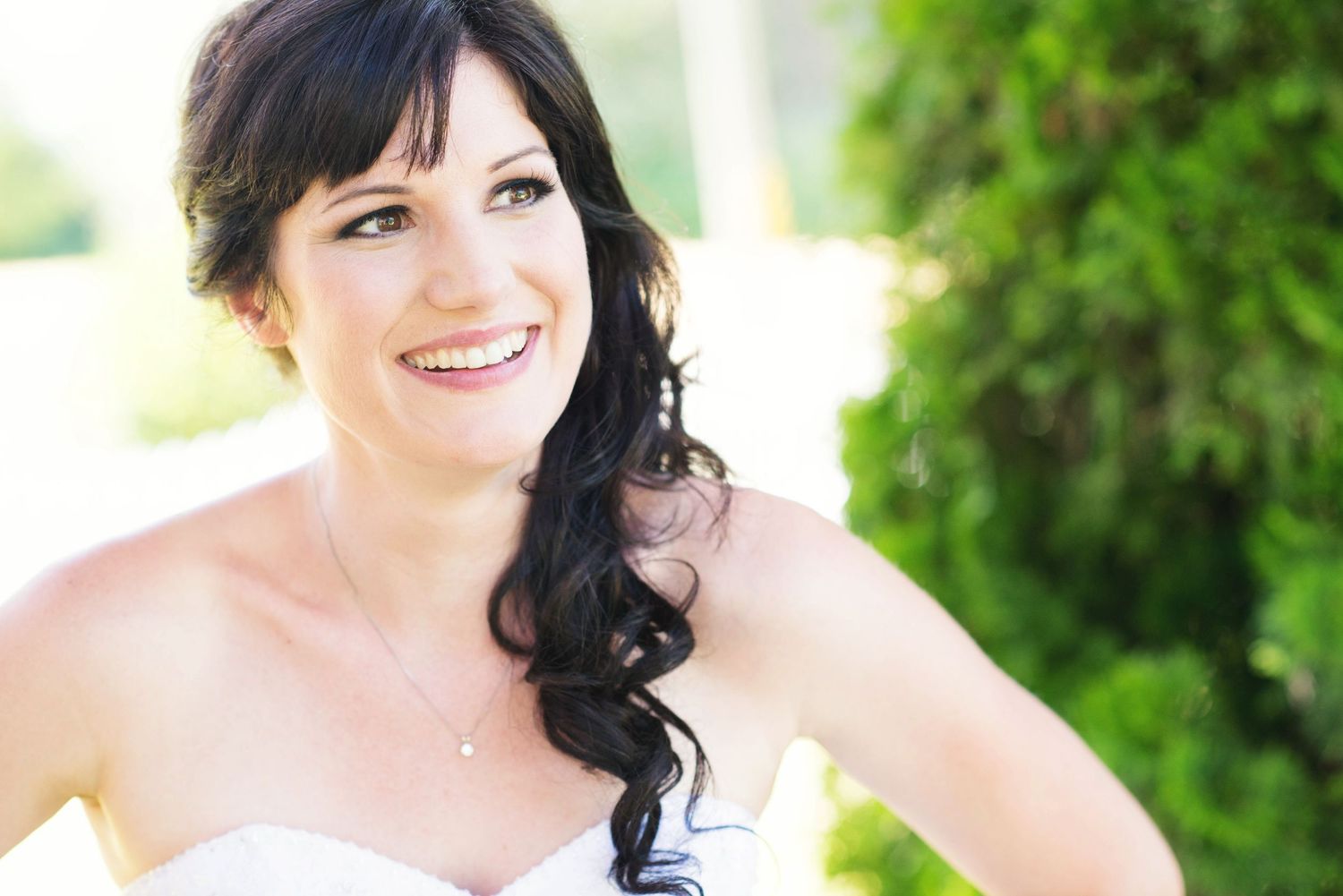 Bride smiling outdoors during a relaxed wedding portrait in British Columbia.