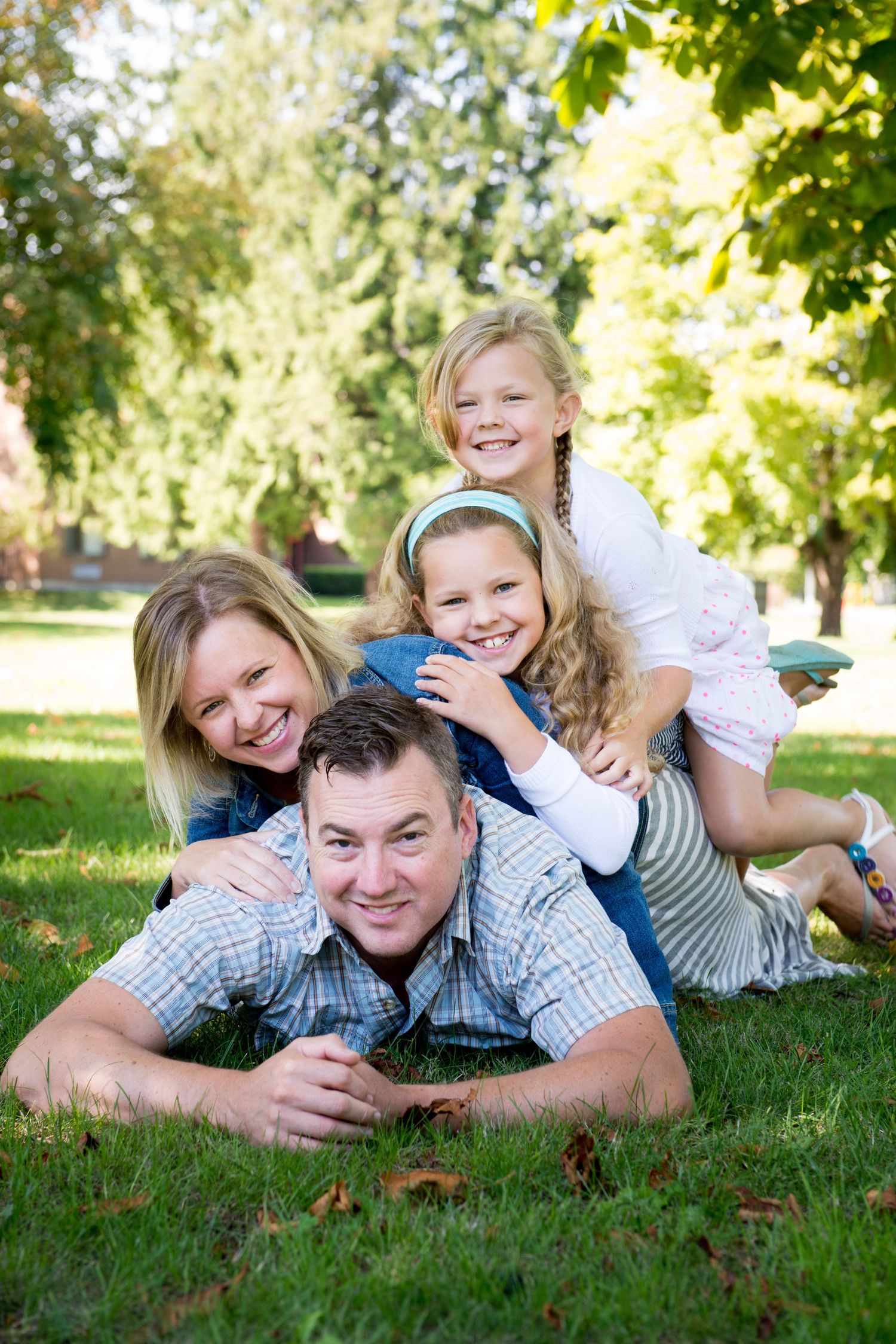 Family of four laughing together during an outdoor portrait session in Chilliwack, British Columbia.
