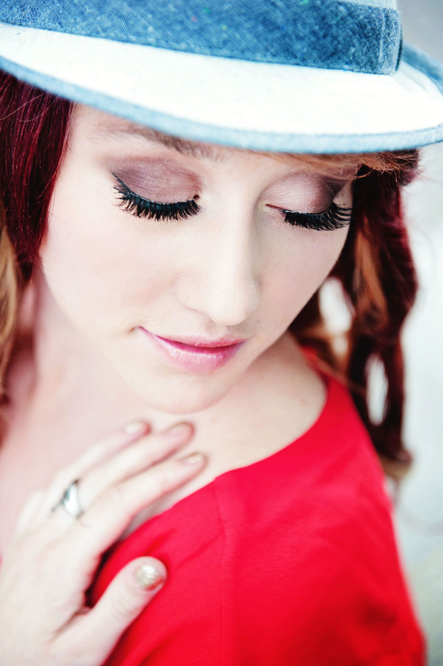 Outdoor portrait of a red-haired young woman with her eyes closed during a portrait session in Chilliwack, British Columbia.