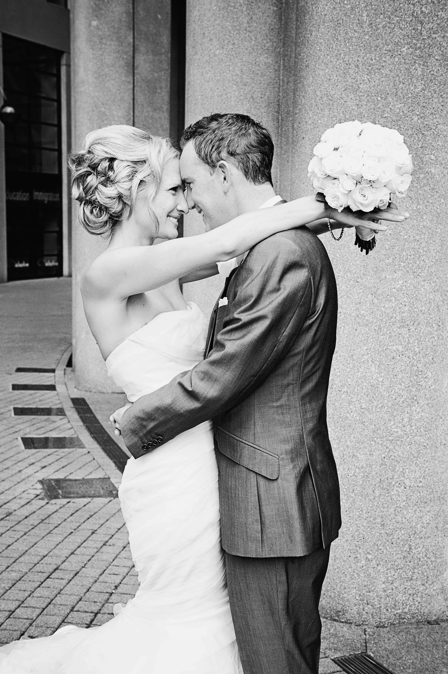 Black-and-white portrait of a bride and groom embracing during their wedding in Vancouver, British Columbia.