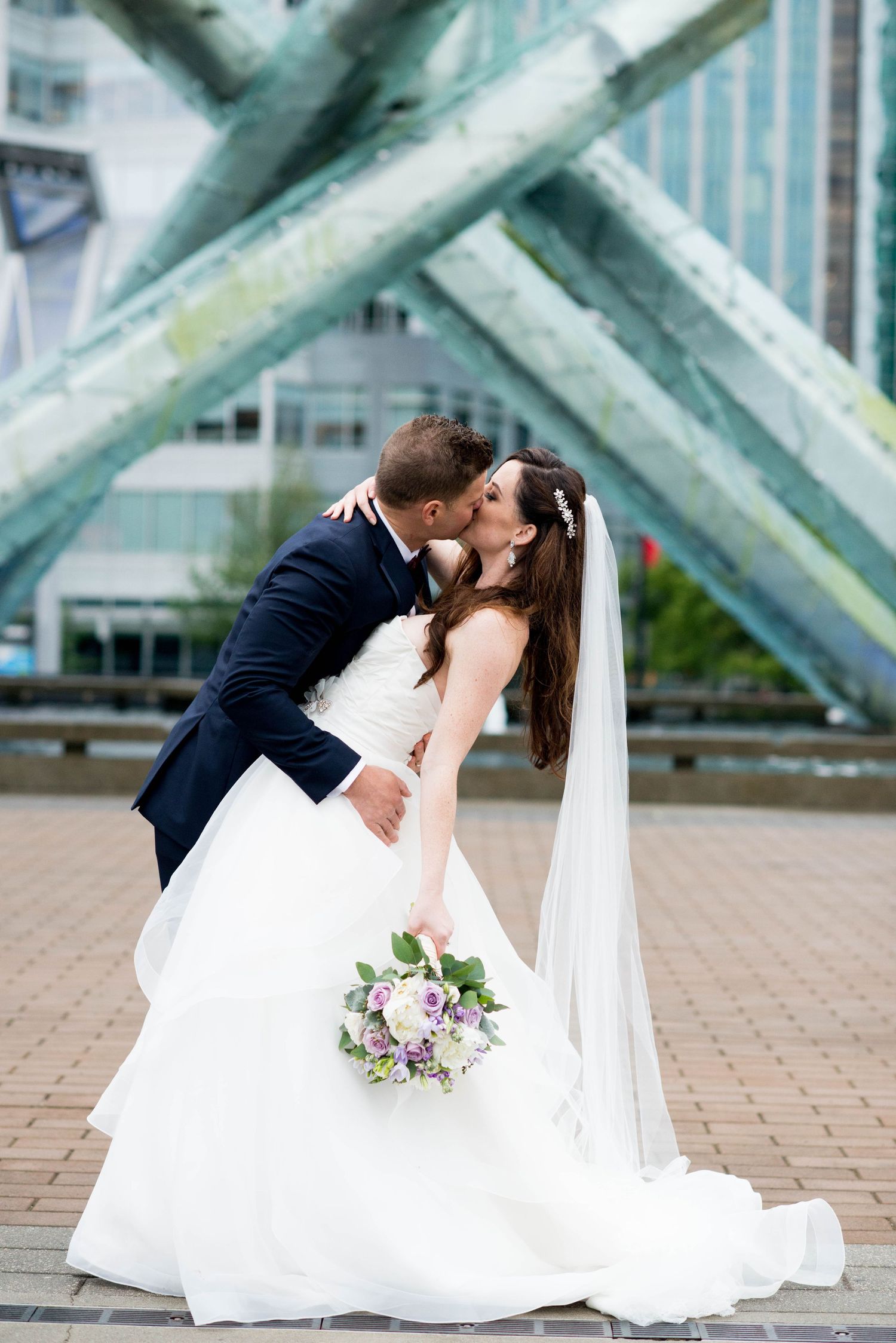 Bride and groom sharing a dip kiss near the Olympic Cauldron in Vancouver, British Columbia.