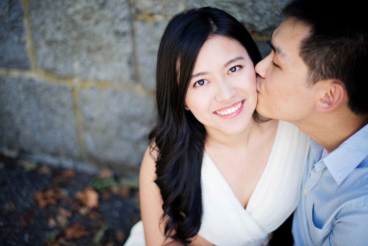 Man kissing his partner on the cheek during an outdoor engagement session in British Columbia.
