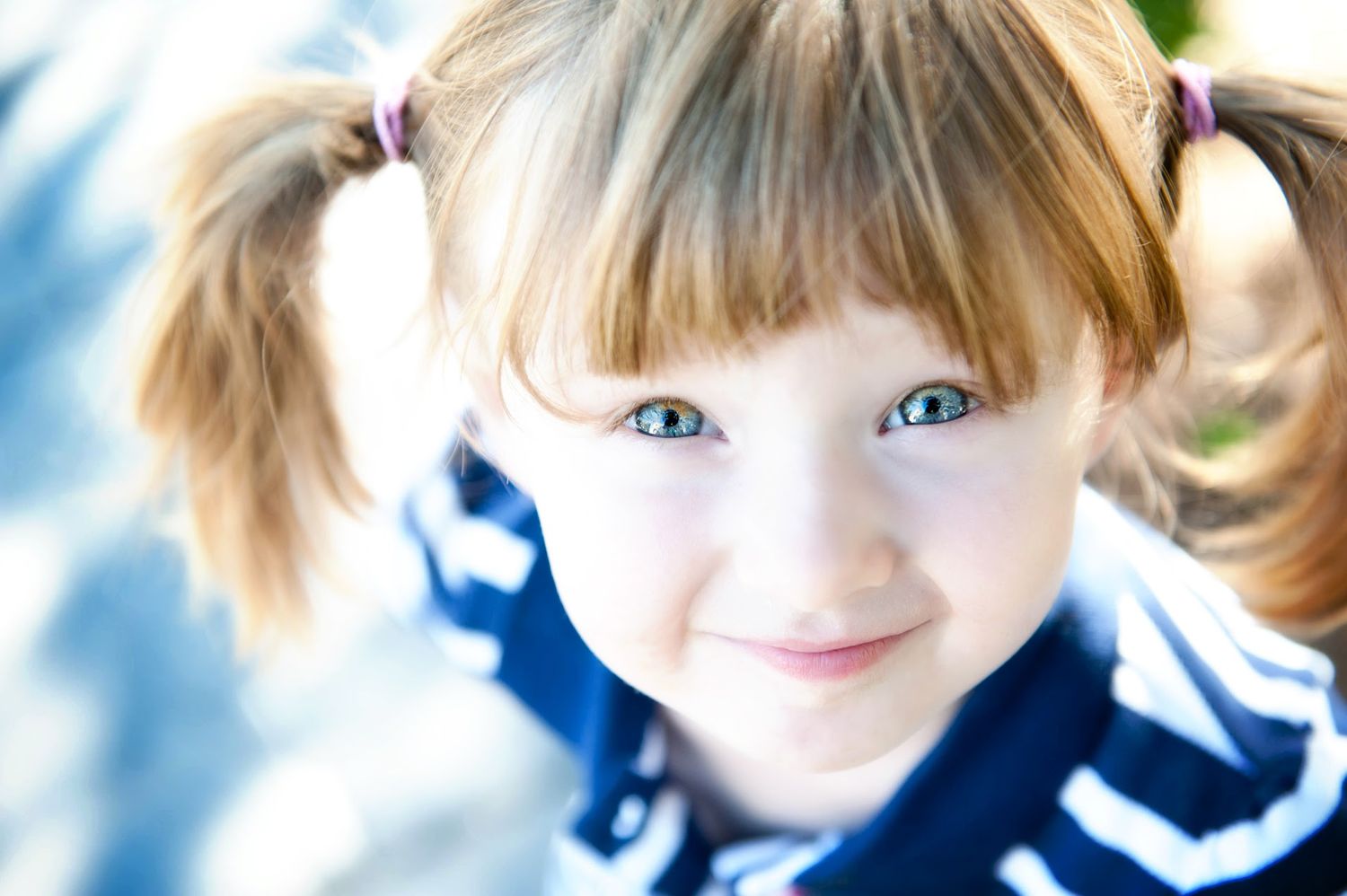 Outdoor portrait of a smiling young girl with pigtails in British Columbia.