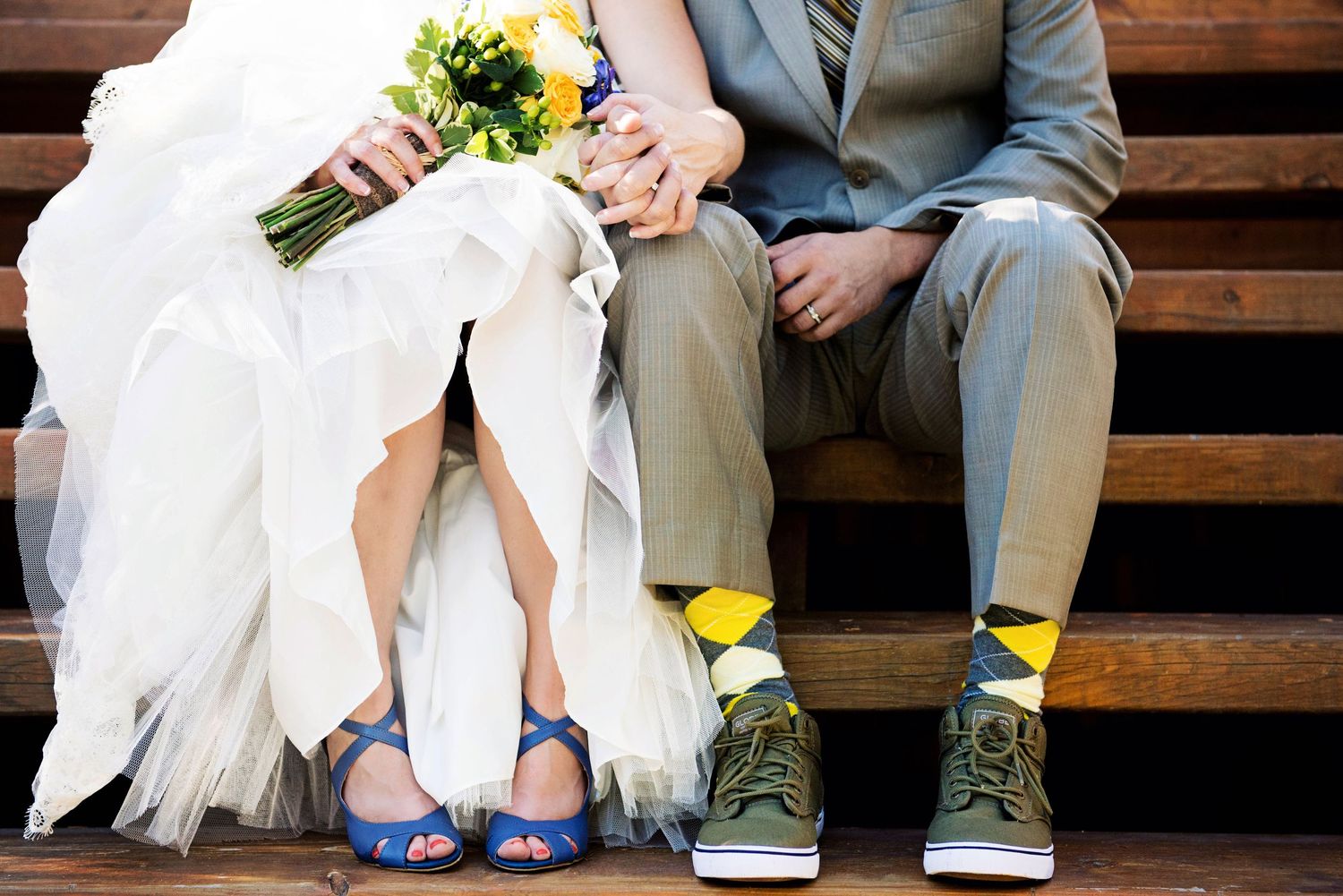 Bride and groom sitting on outdoor steps in Valemount, British Columbia, showing the bride's blue shoes and groom's colourful socks.