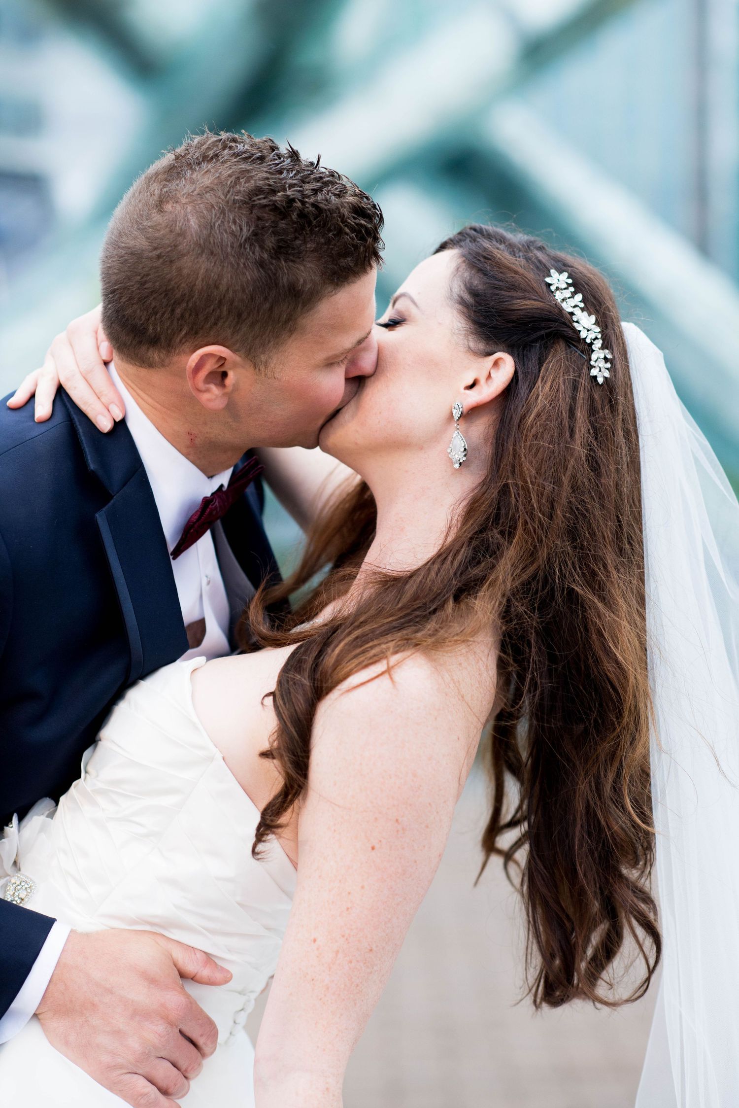 Bride and groom kissing near the Olympic Cauldron during their wedding portraits in Vancouver, British Columbia.