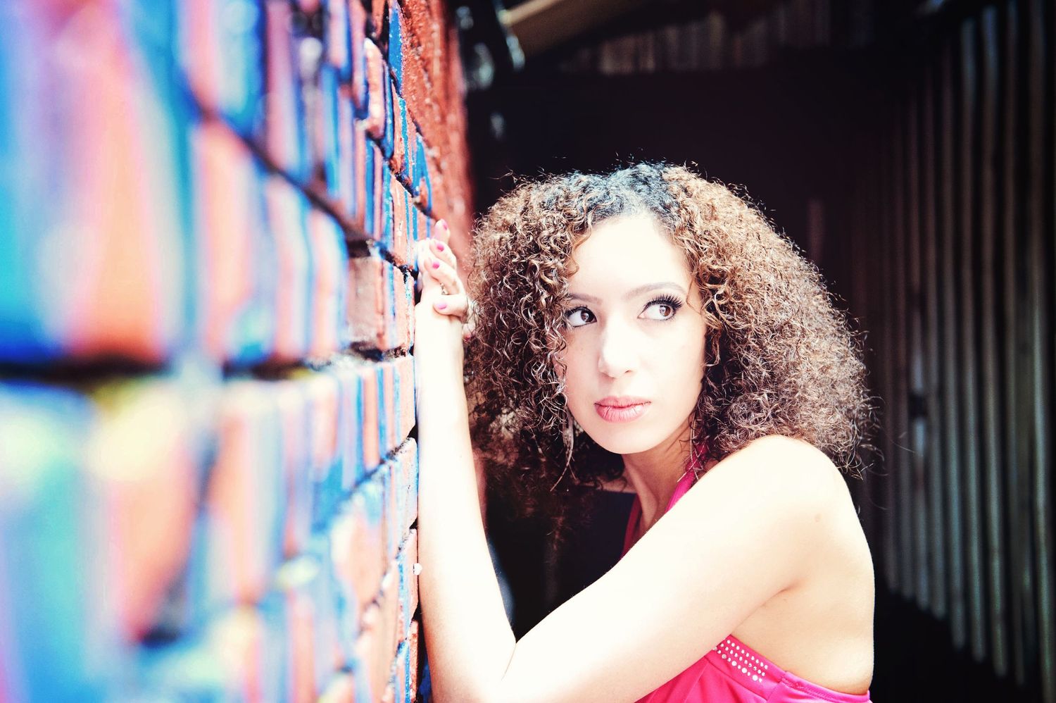 Graduation portrait of a young woman standing beside a colourful graffiti wall in Vancouver, British Columbia.