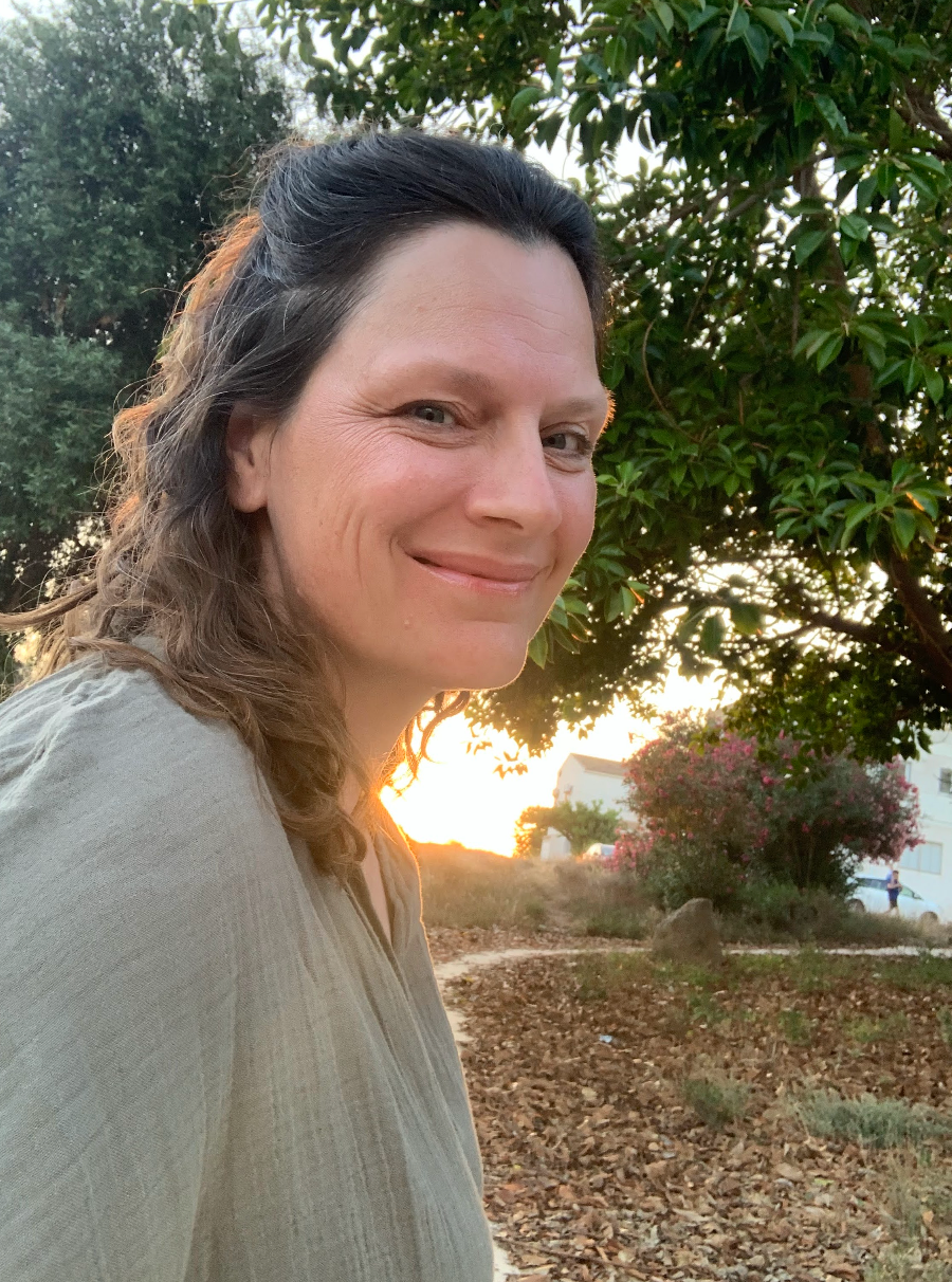 Selfie captured at sunset with golden sunlight peeking through tree branches in a peaceful outdoor setting.