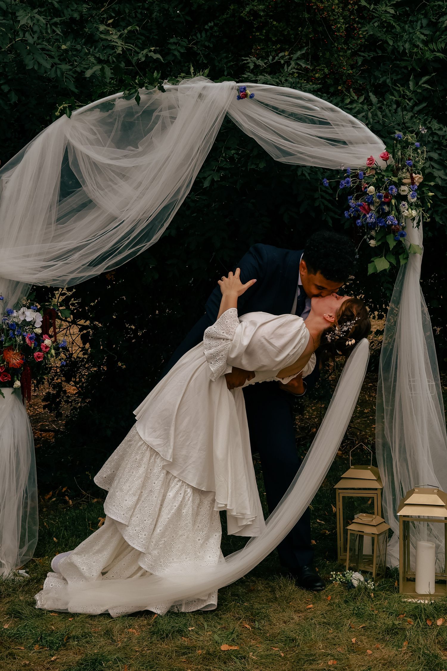 A sequence of flowing white wedding dress movements captured against a garden backdrop with lanterns and draped fabric.