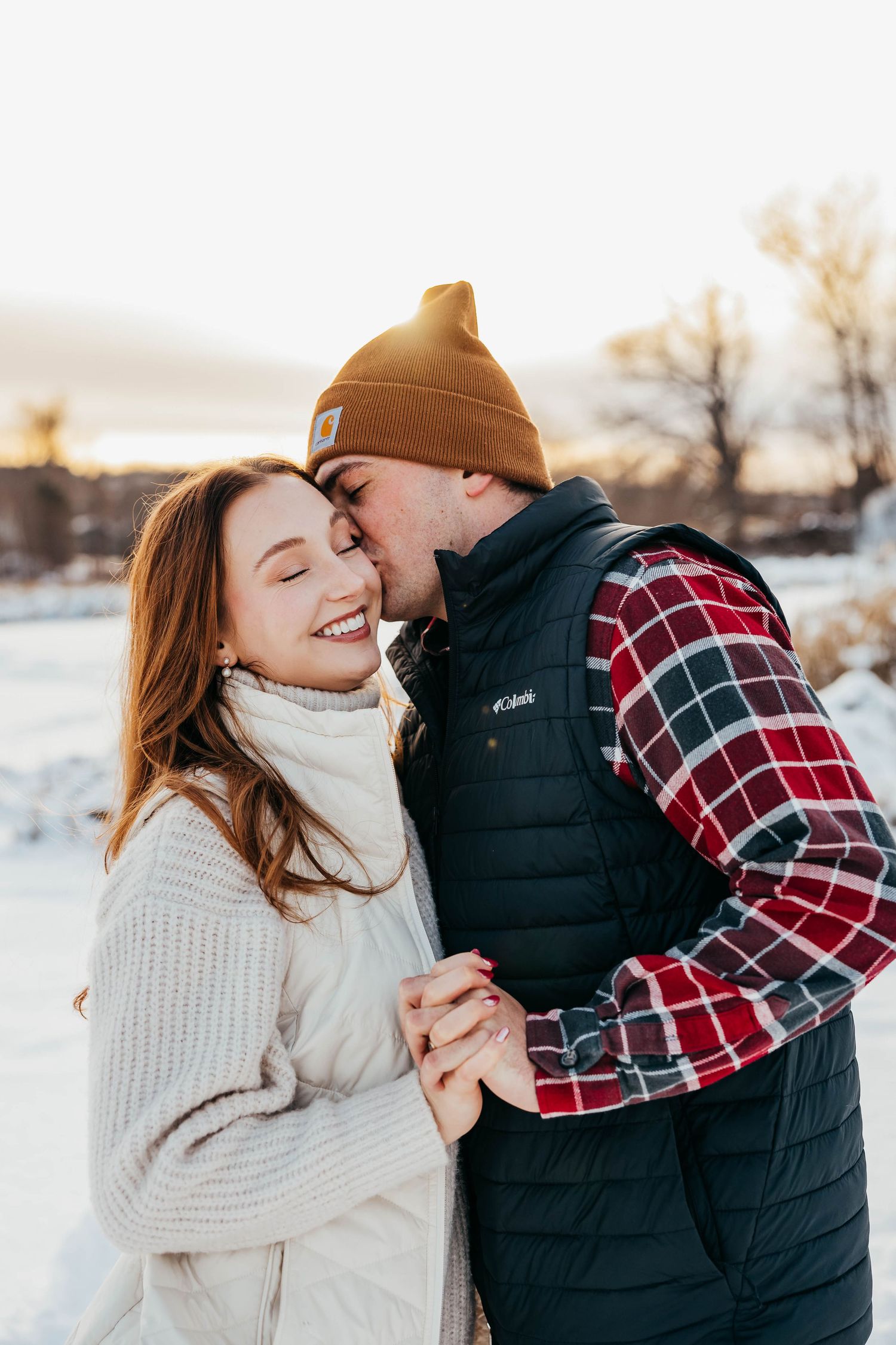 Cozy winter couple moment with snowy landscape in background.