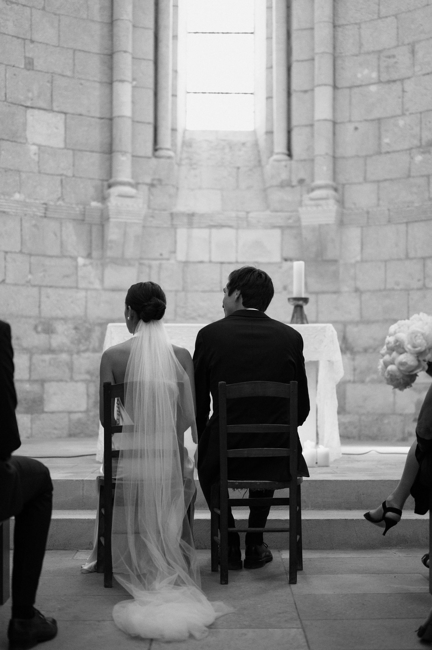 Black and white sequence in a stone church showing intimate moments during a wedding ceremony.