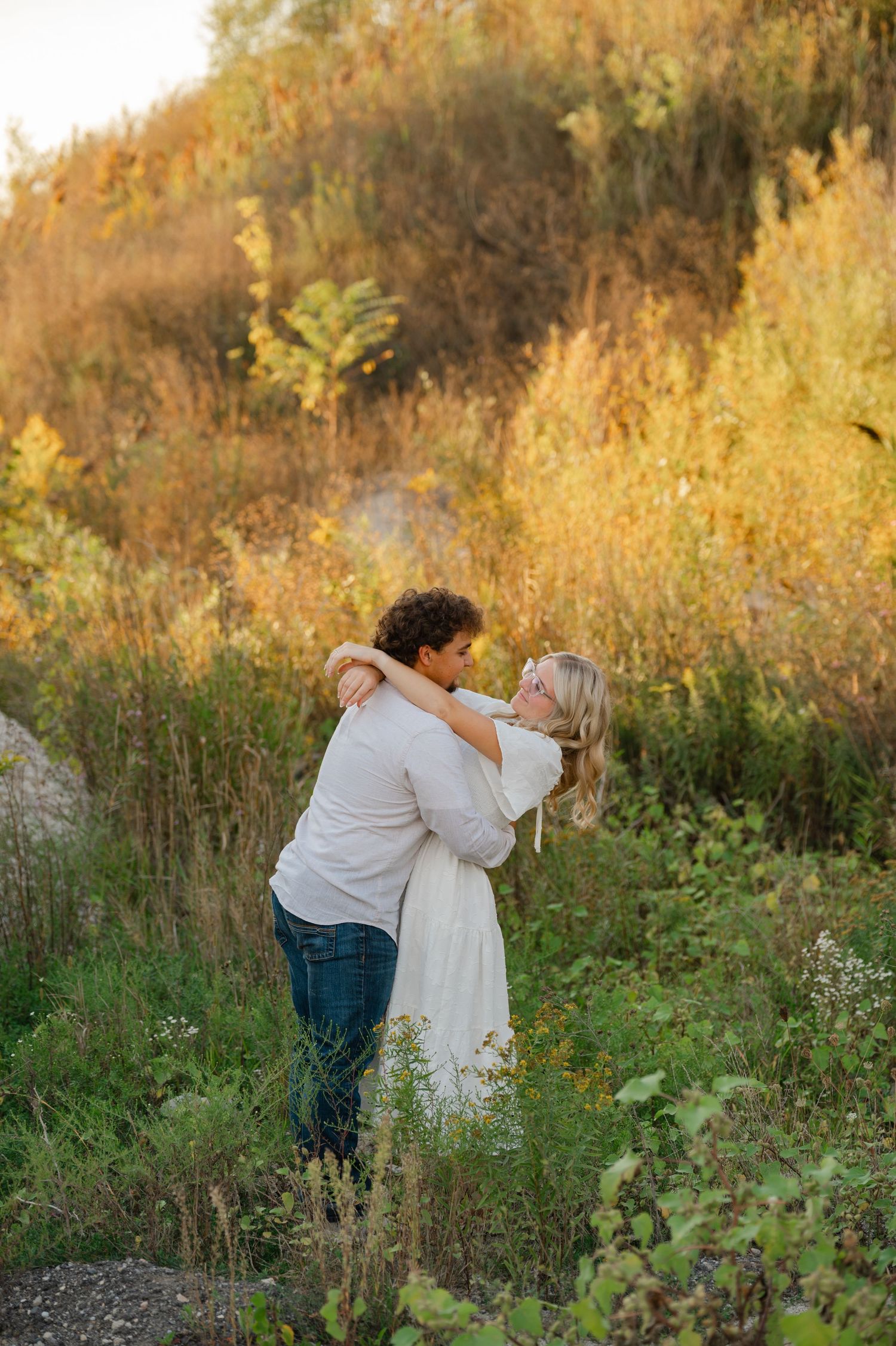 engaged couple doing a slight dip back looking at eachother