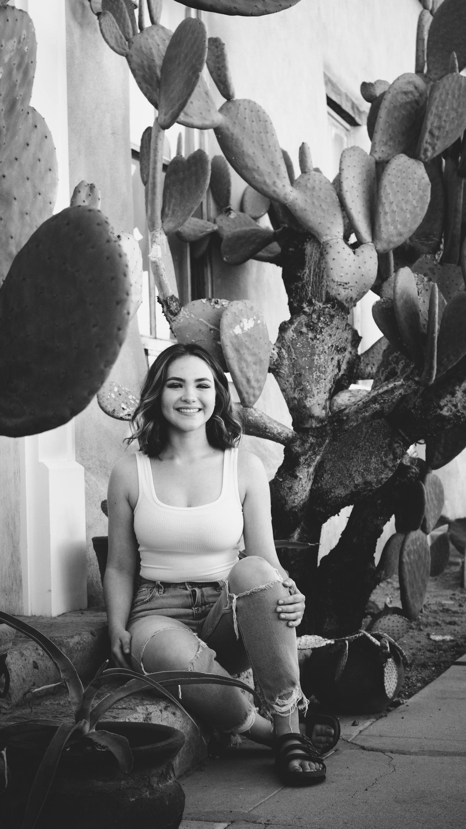 Black and white portrait with a prickly pear cactus backdrop.