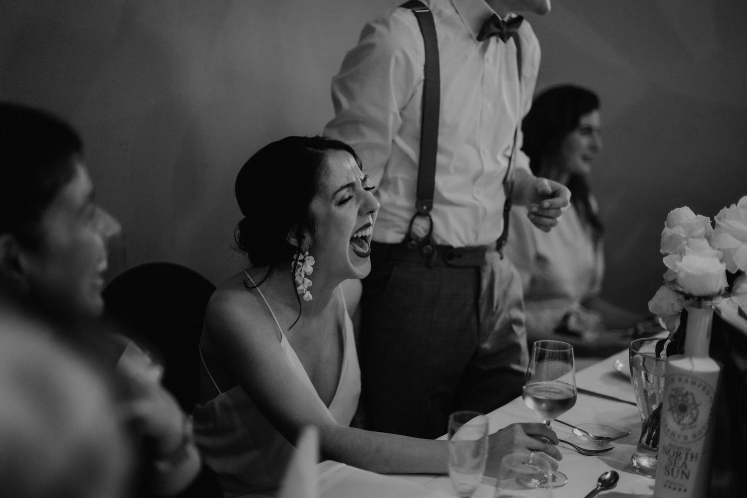 Moody black and white reception photography capturing natural social interactions.