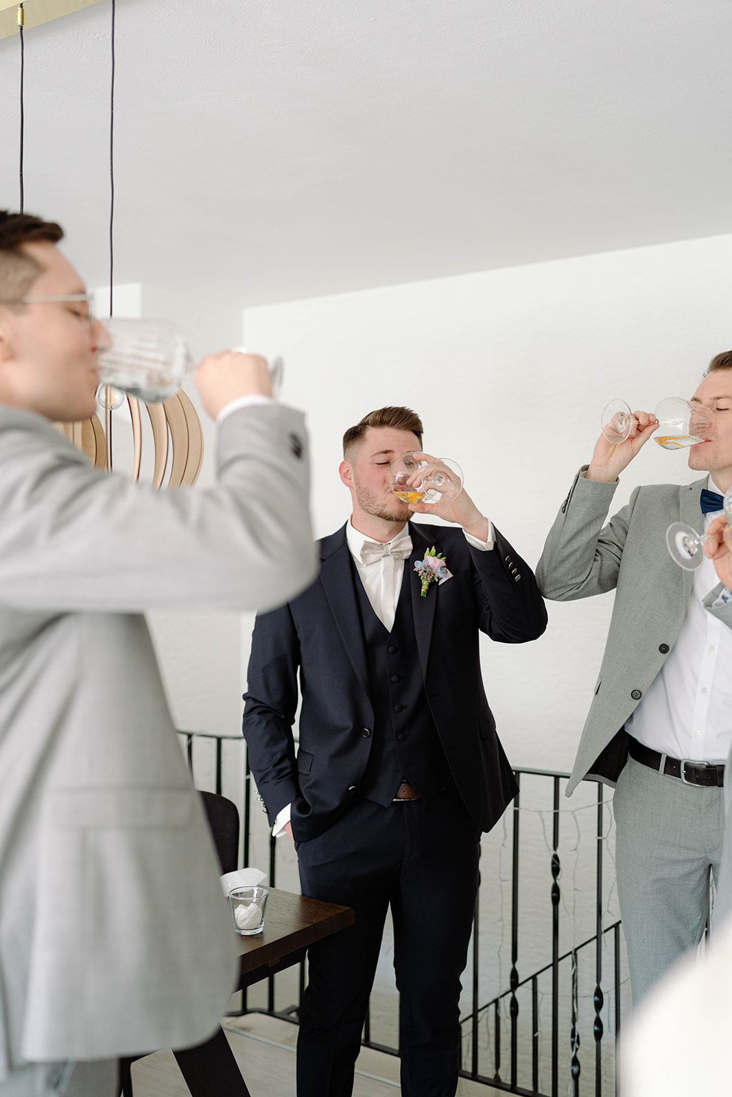 Wedding party members in formal attire taking celebratory drinks together.