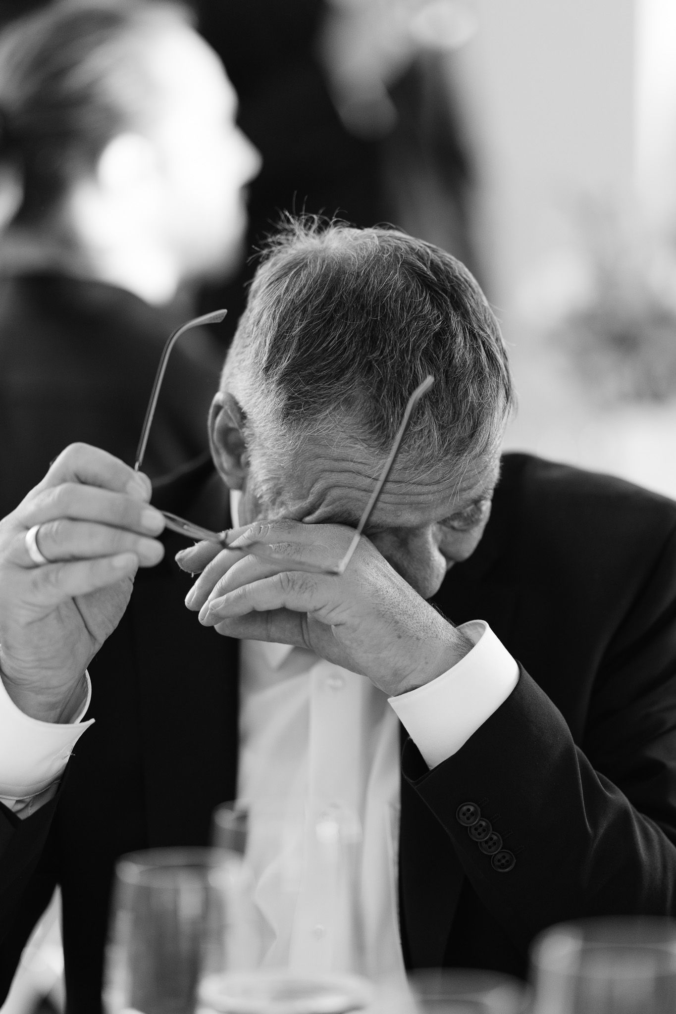 Series of emotional black and white photos showing wedding guests wiping tears during ceremony.