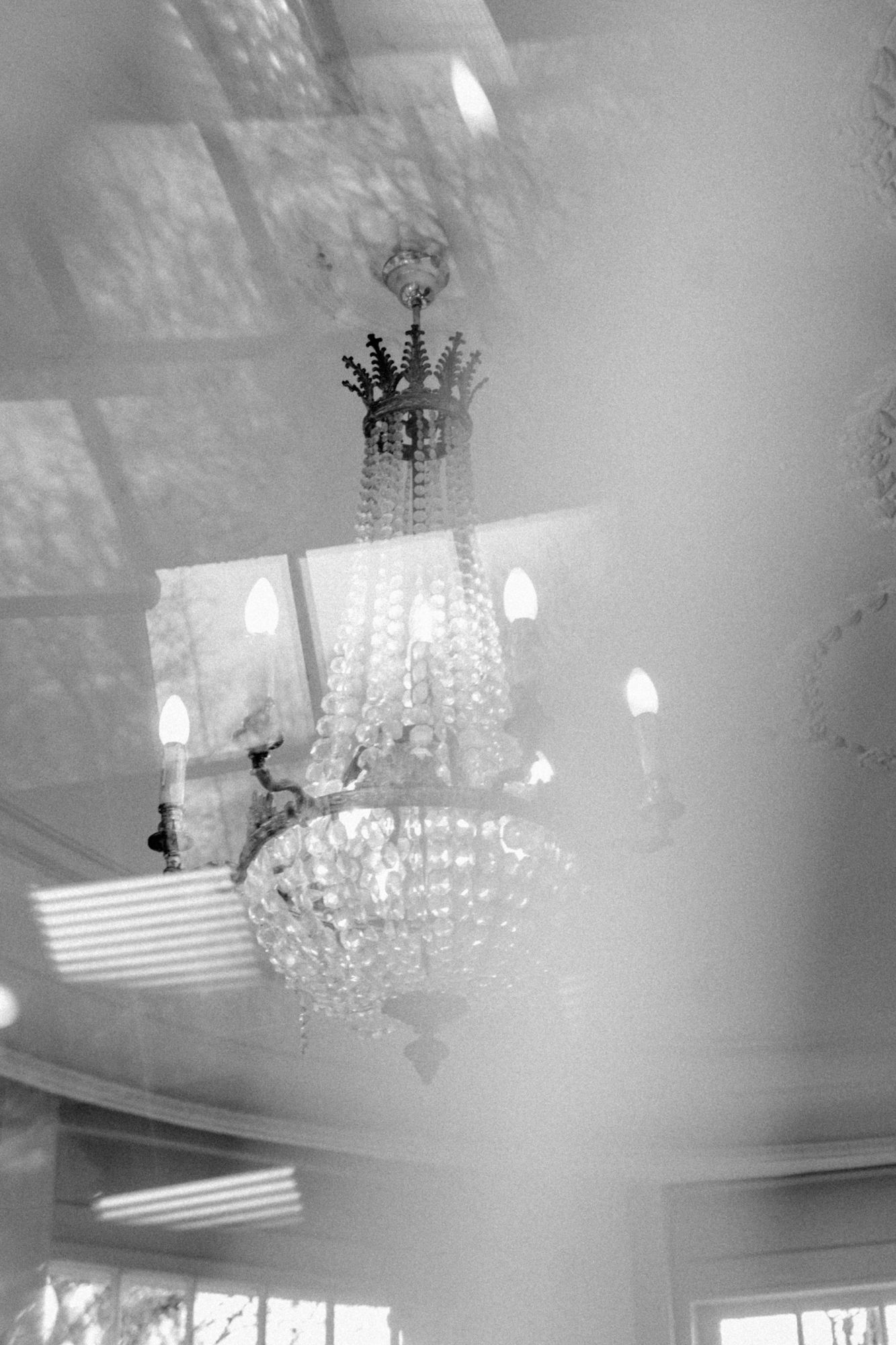 Sophisticated crystal light fixture hanging from a modern white ceiling.