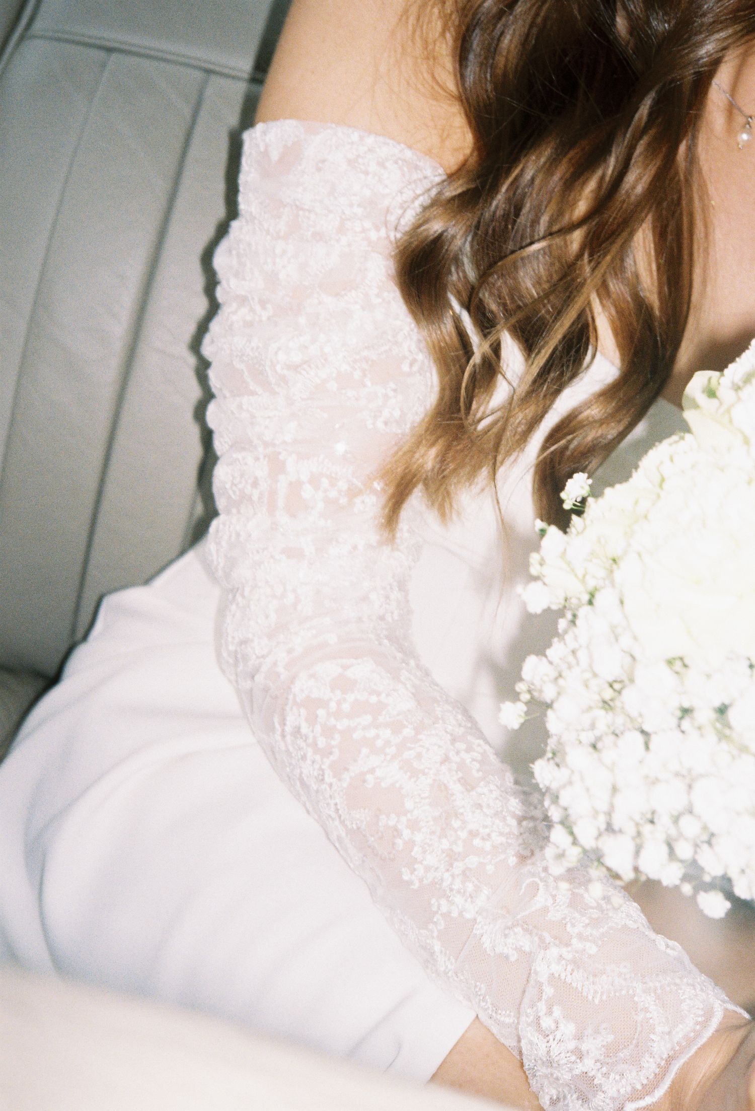 Detail of delicate white lace and floral embellishments on wedding attire.