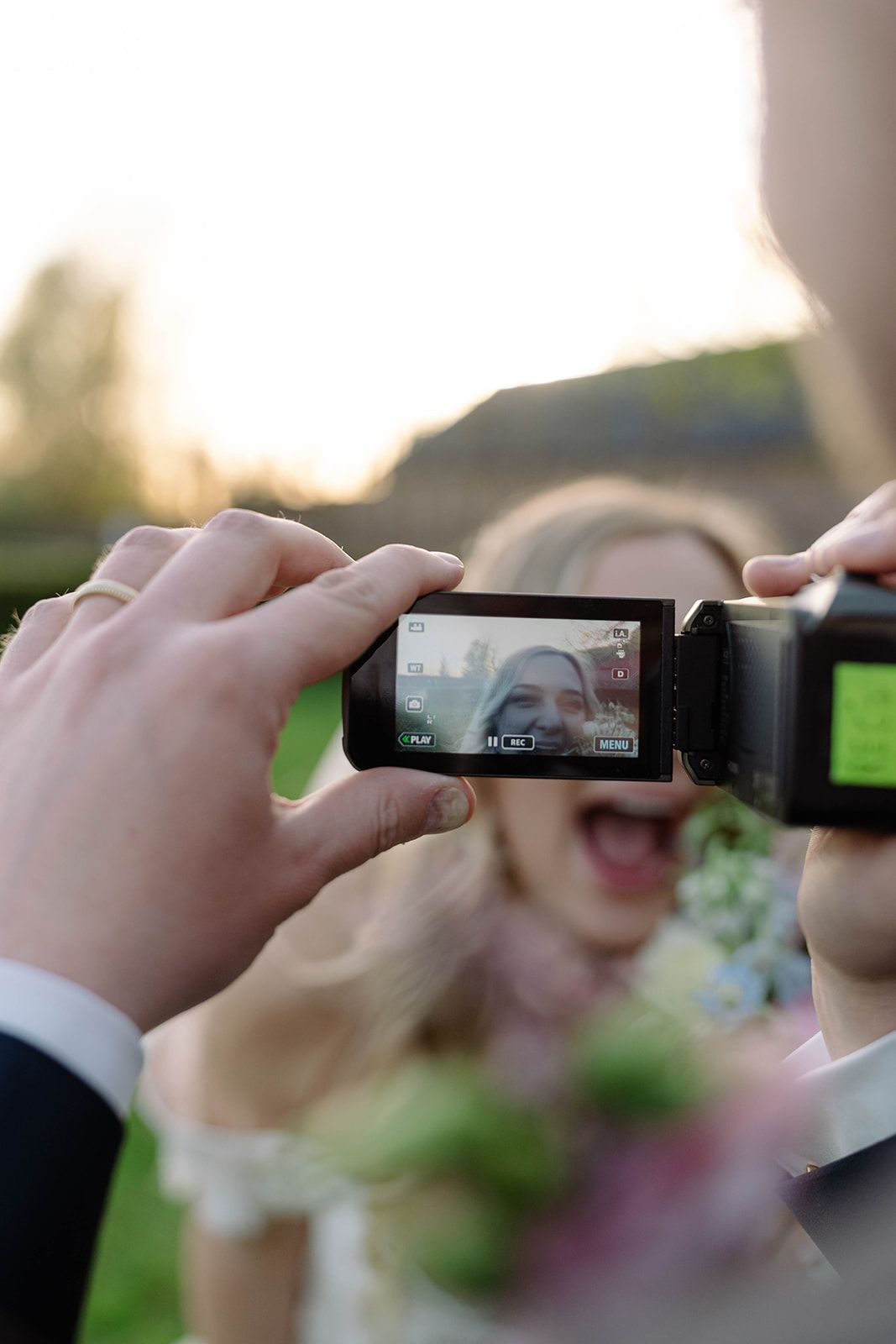 Series of hands holding phones to capture photos at an outdoor event.