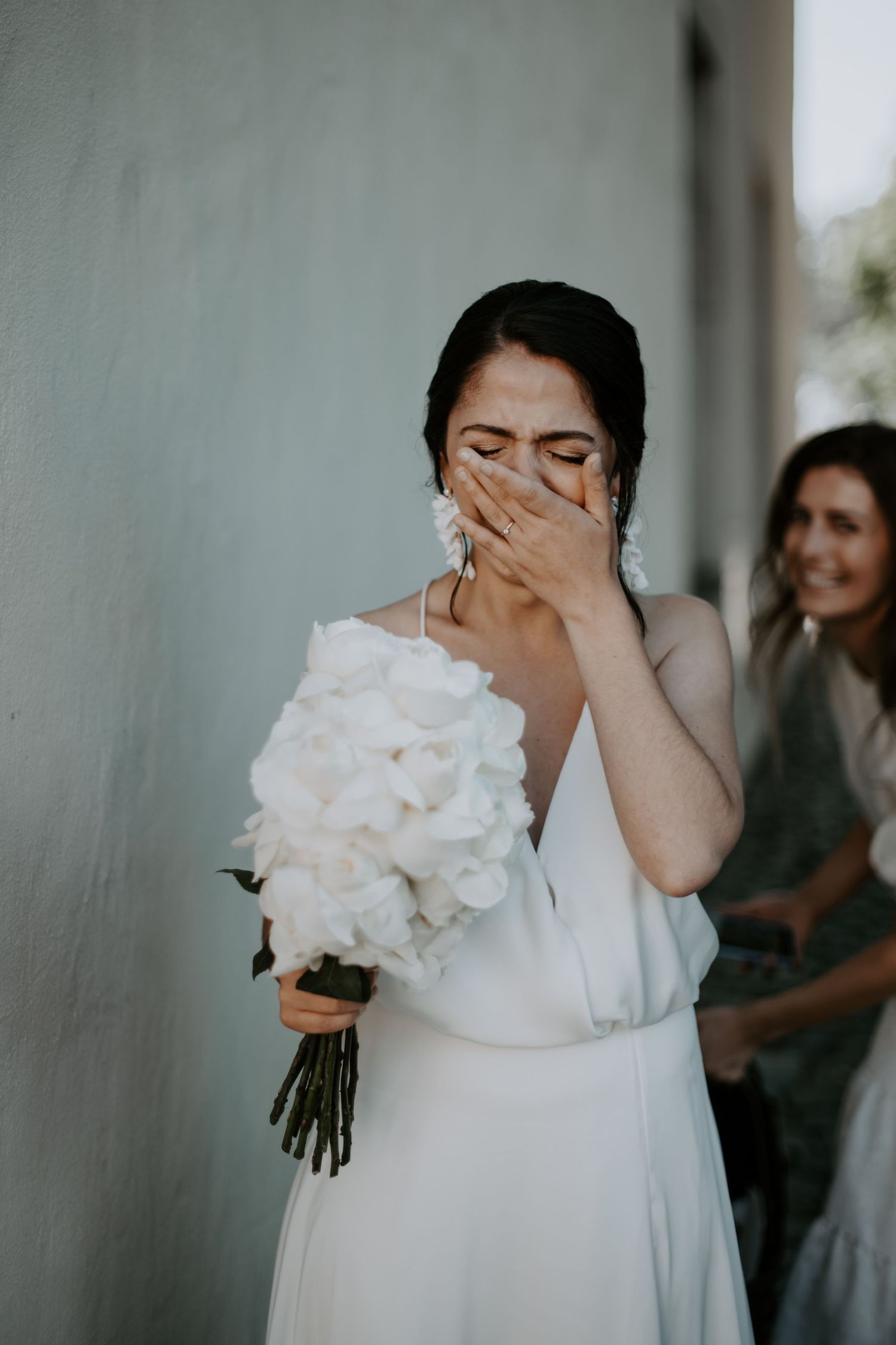 Emotional bridal sequence showing tender moments with white floral bouquet.