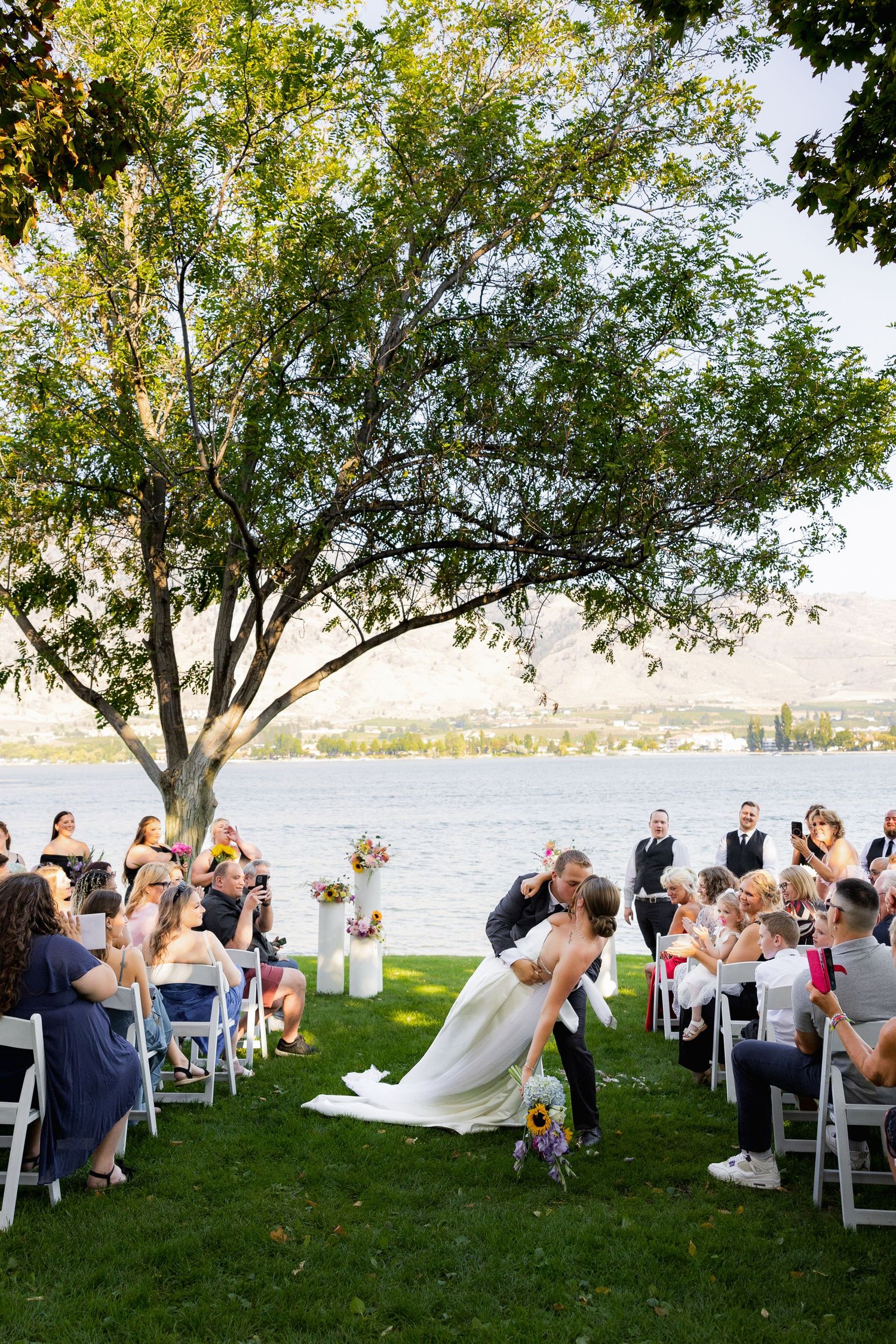 Luxury wedding photo of newlywed couple kissing after ceremony, capturing romantic, intimate, and stylish wedding photography moments.