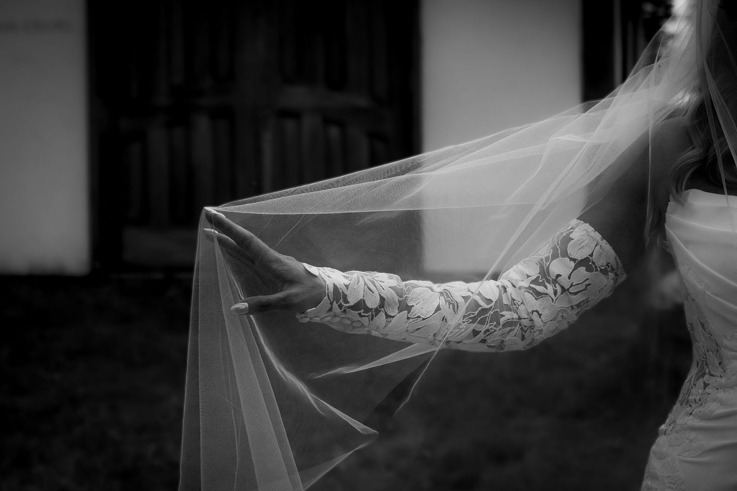 Bridal detail photo of brides hand under the veil in a black and white frame captured by a wedding photographer in British Columbia