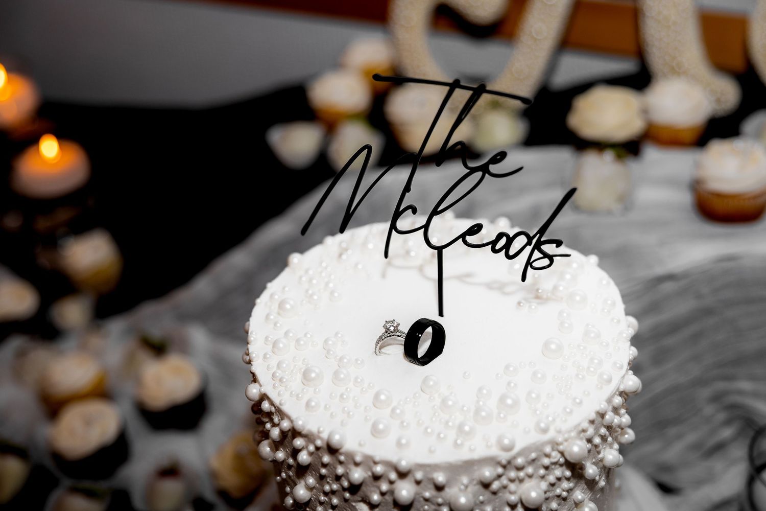 Wedding detail photo of wedding cake with rings, capturing elegant, stylish, and romantic bridal accessories and wedding photography.