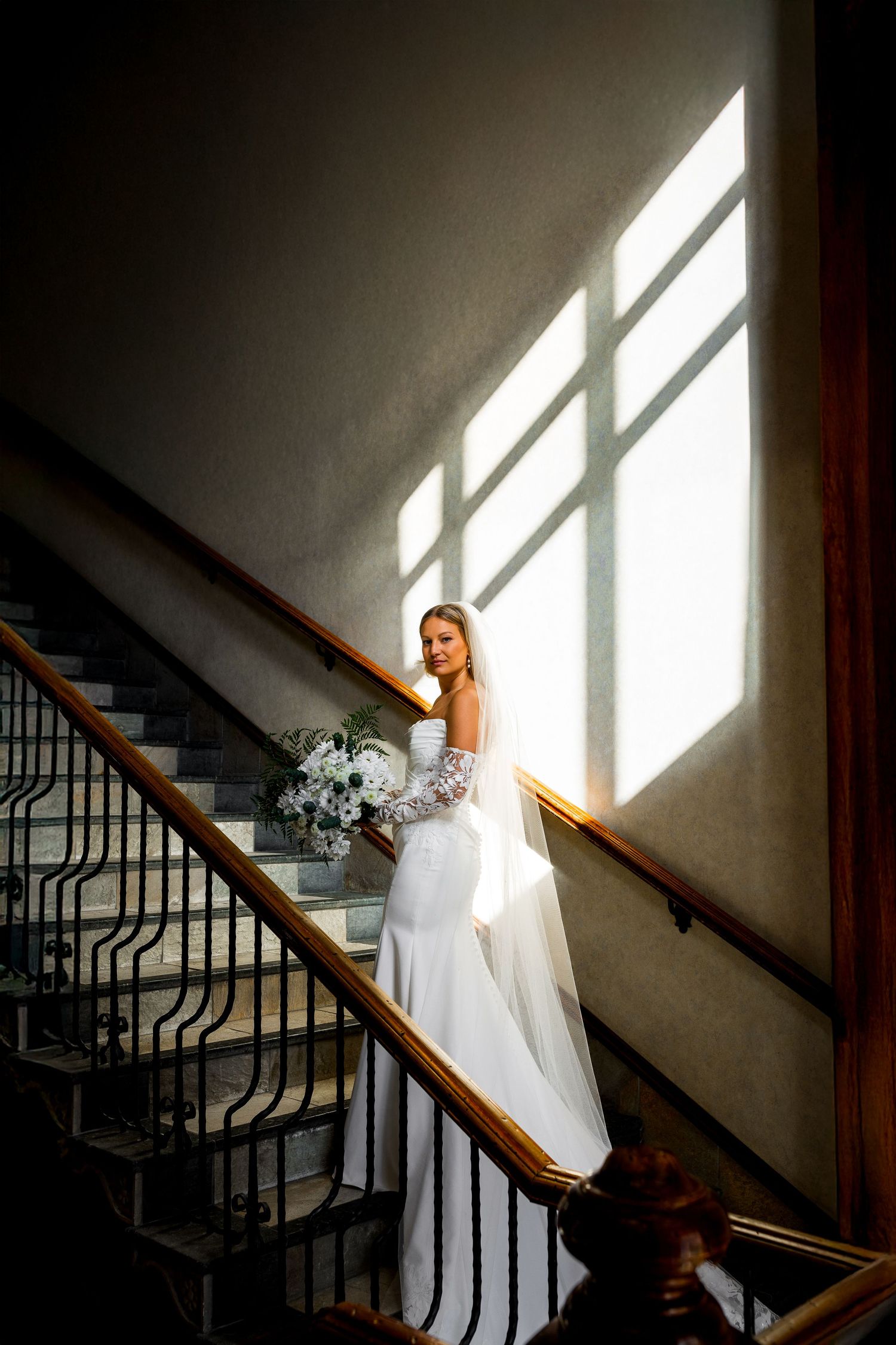 Luxury bridal portrait of bride on staircase at Sun Peaks Grand, capturing elegant, romantic, and stylish destination wedding photography.