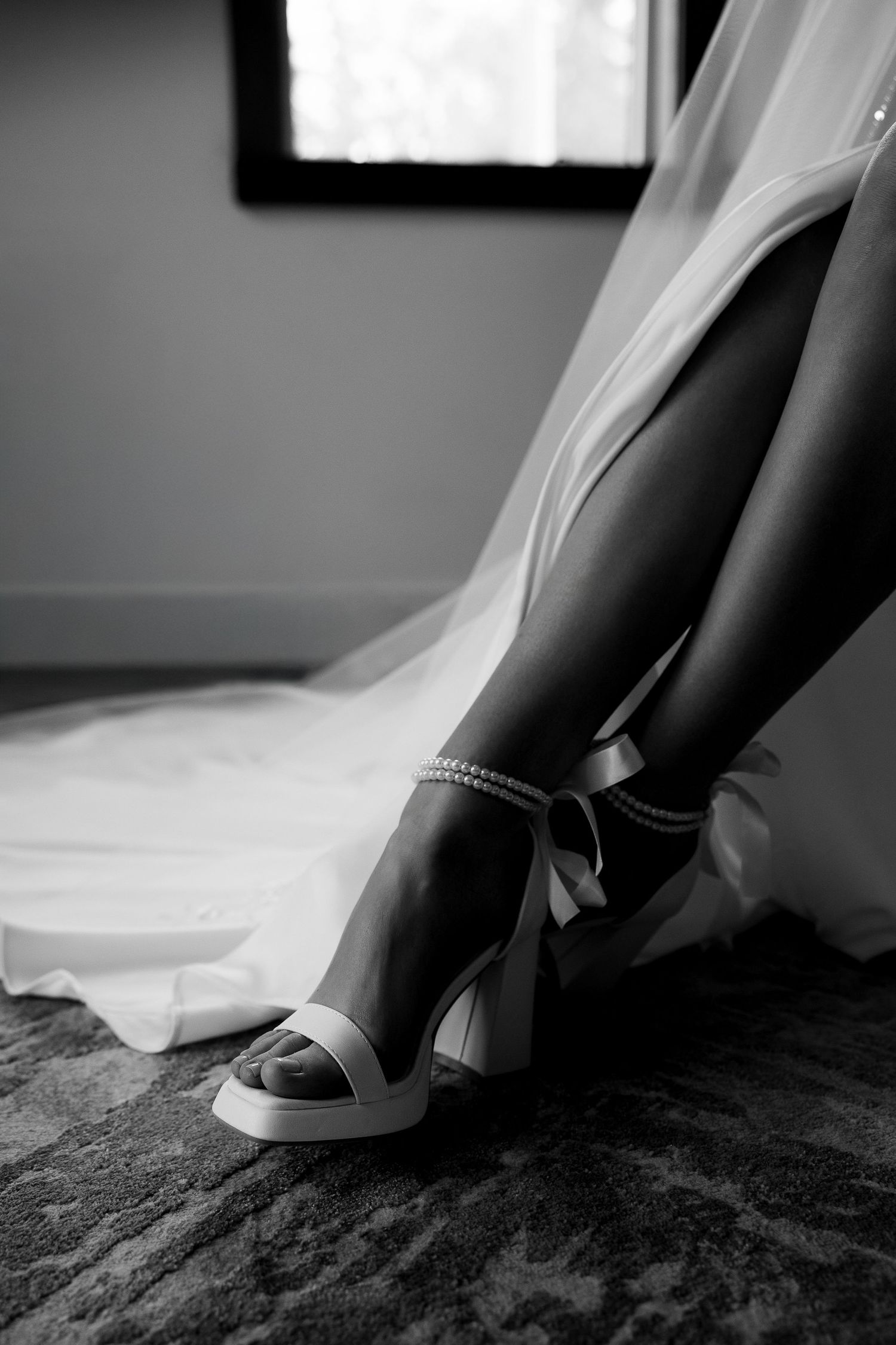Elegant wedding detail photo of bride’s legs and shoes, capturing stylish bridal accessories and luxury wedding photography.