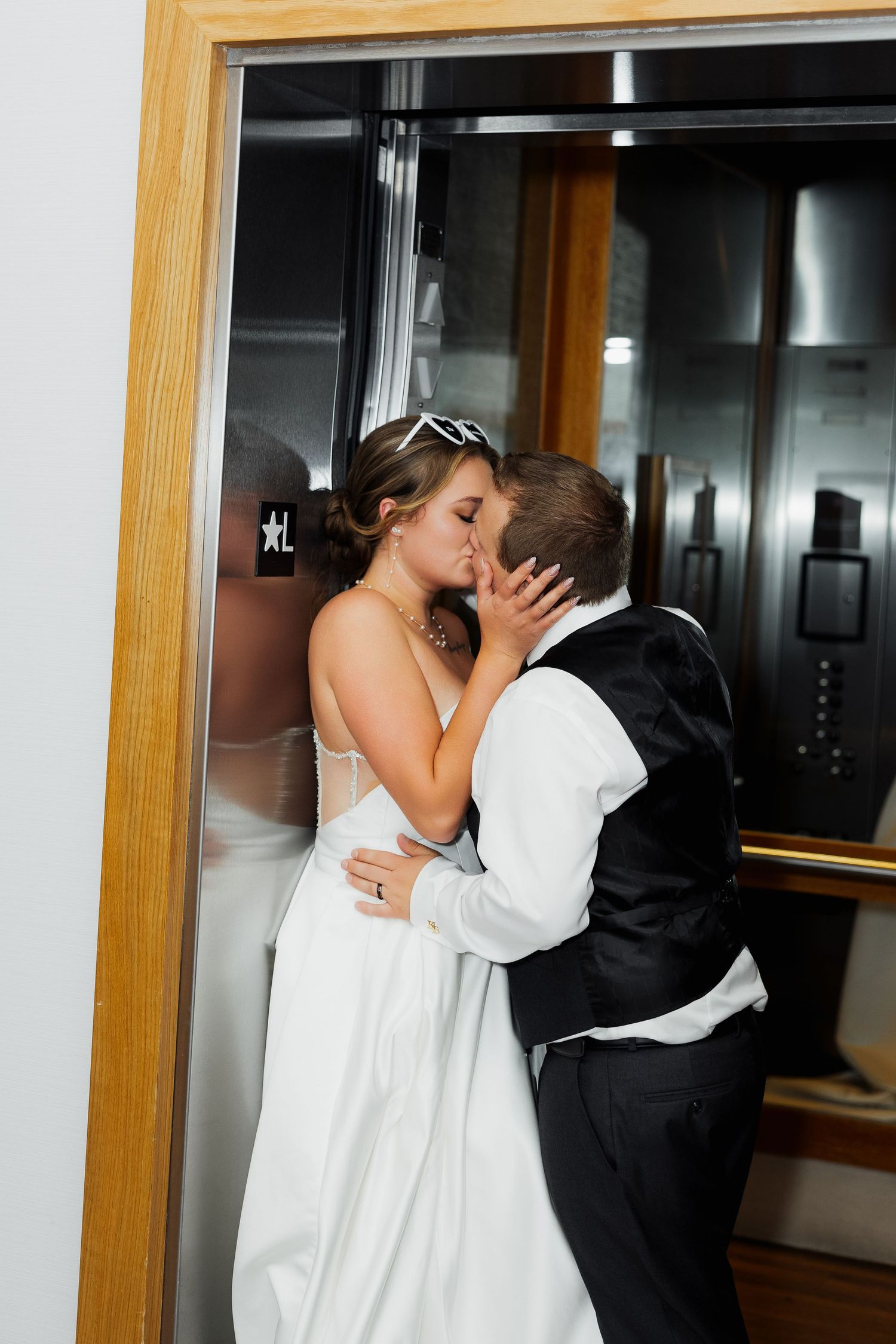 Luxury wedding photo of newlyweds kissing in elevator at Watermark Beach Resort Osoyoos, capturing romantic and stylish wedding photography.