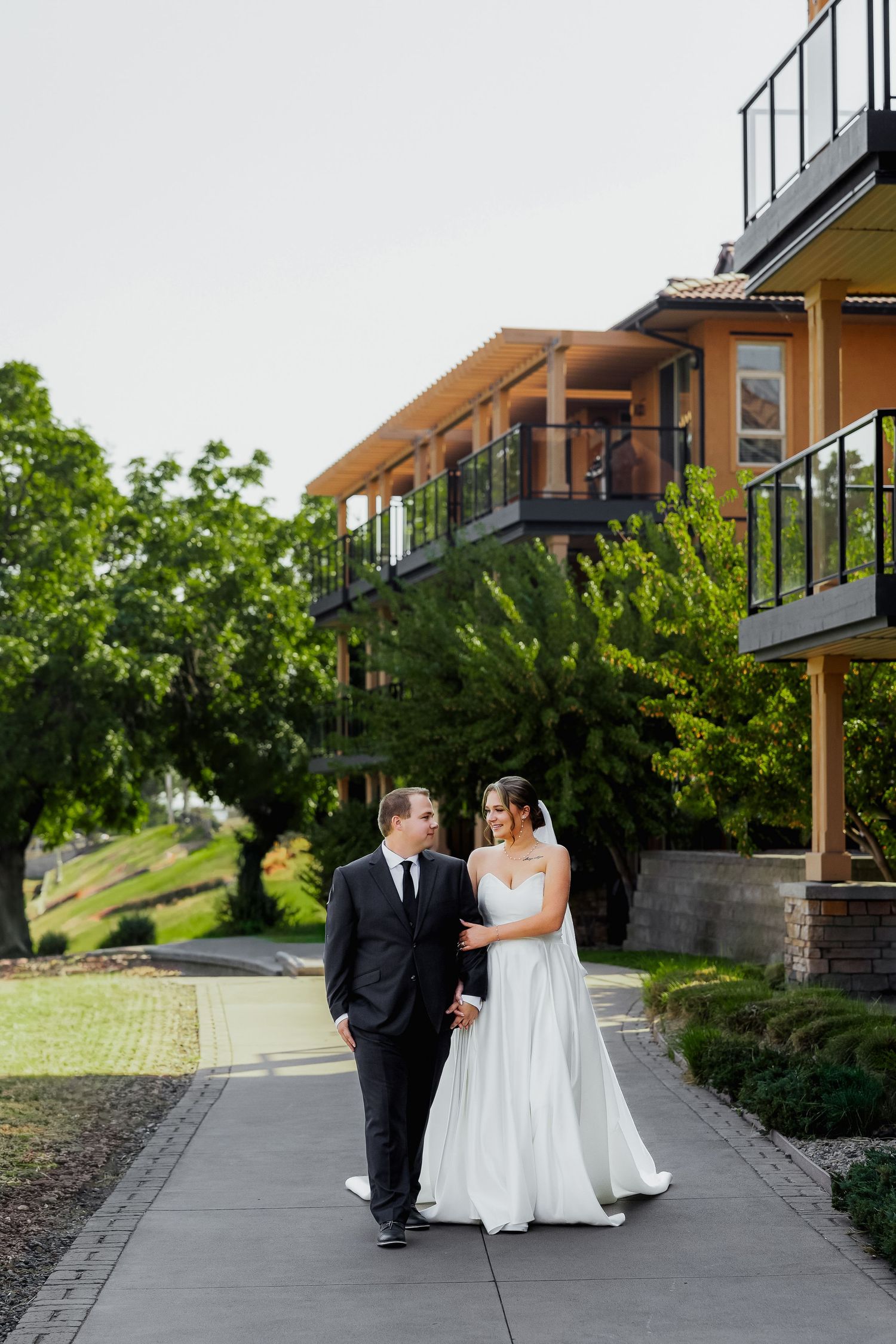 Luxury wedding photo of newlyweds walking at Watermark Beach Resort in Osoyoos, capturing romantic destination wedding photography.