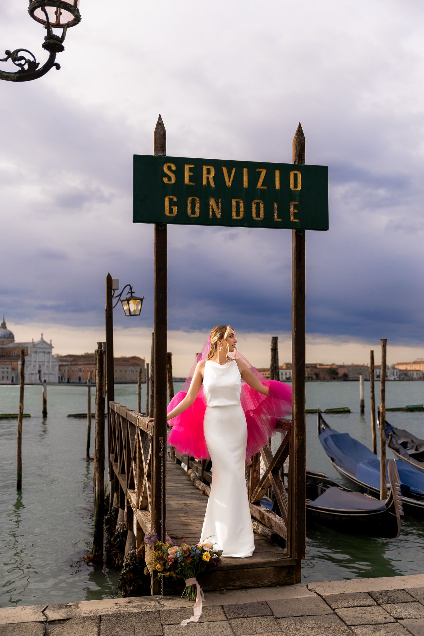 Bridal portrait in pink veil by gondola pier in Venice, capturing romantic, editorial, and luxurious destination wedding photography.