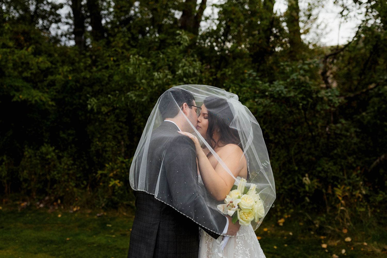 Luxury wedding photo of couple kissing under veil at The Dunes, capturing romantic, intimate, and stylish destination wedding photography.