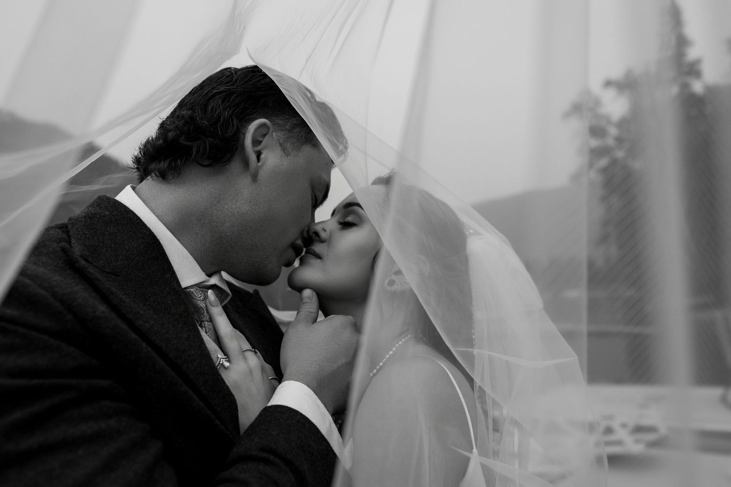 Under the veil kiss shared by a couple on their wedding day.