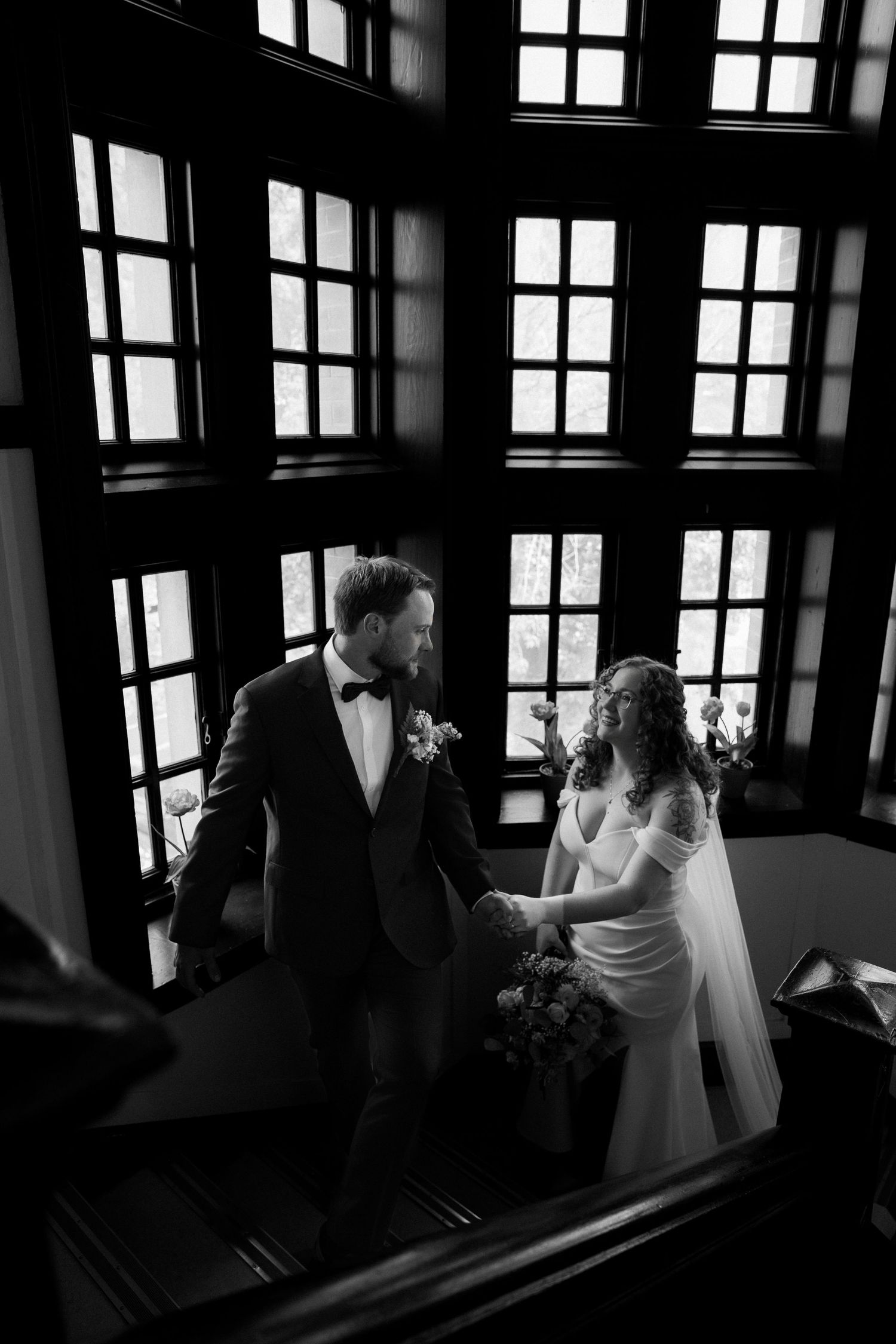 Luxury wedding photo of couple ascending stairs at Kamloops Courthouse to their ceremony, capturing romantic and stylish wedding moments.