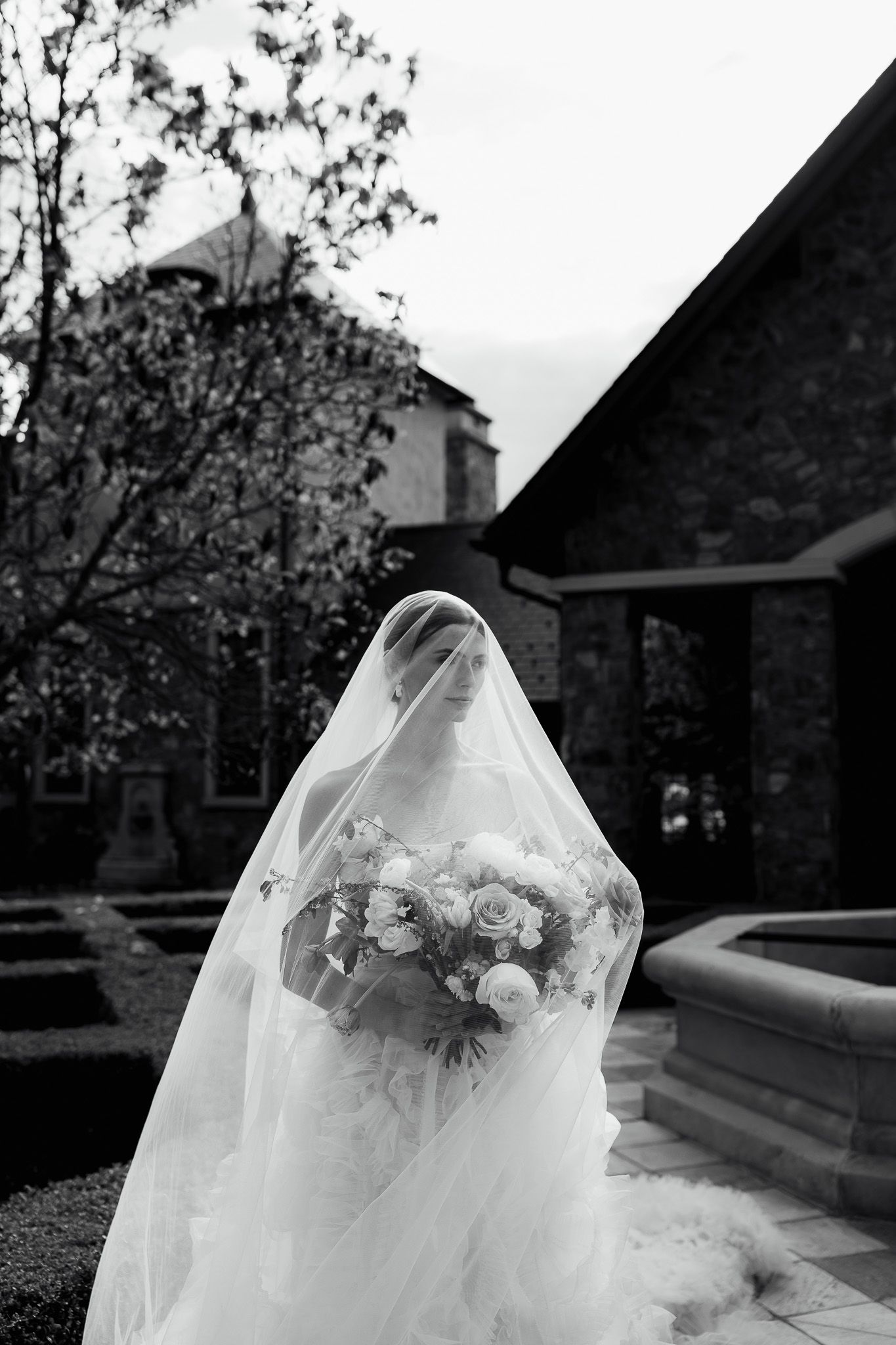 Luxury bridal portrait of bride under veil outside Chateau Okanagan, capturing elegant, romantic, and stylish wedding photography moments.