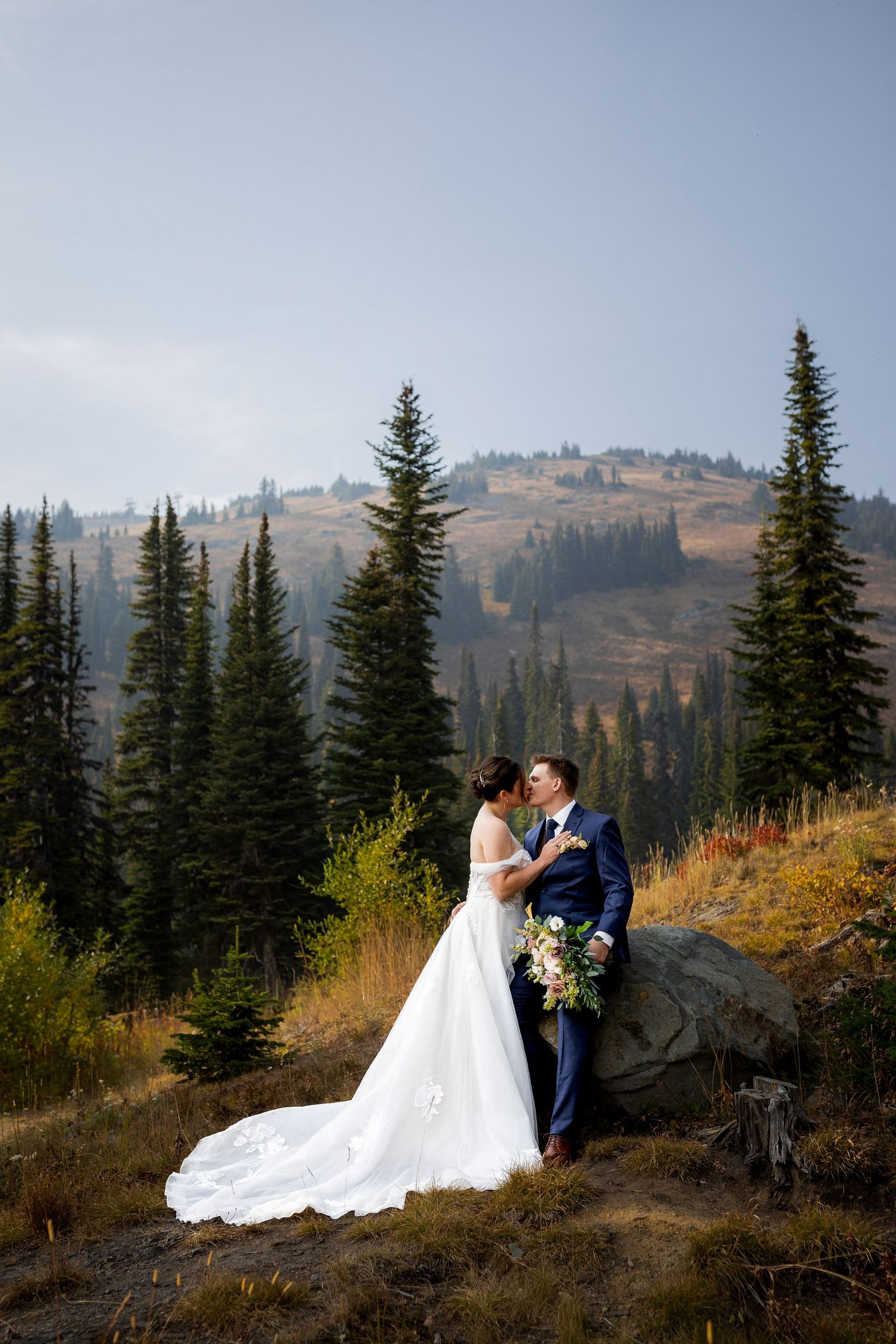 Romantic wedding portraits of bride and groom at Sun Peaks Resort with stunning mountain views, capturing intimate and memorable moments.