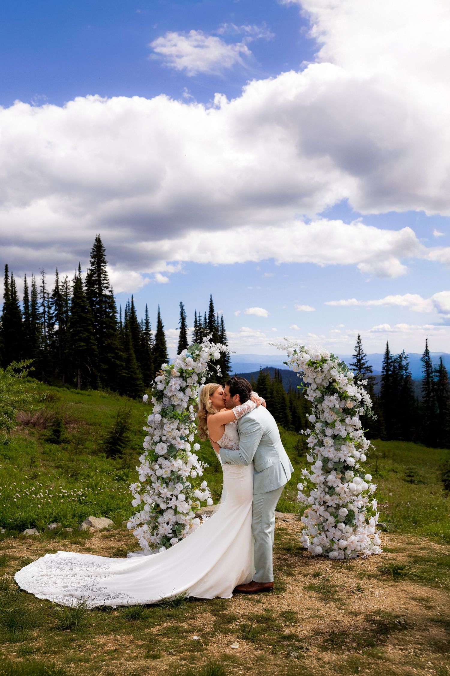 First kiss photo of bride and groom during their ceremony mid-mountain at Sun Peaks Resort.