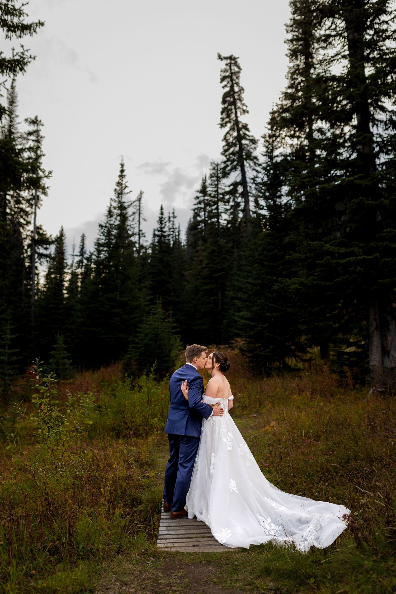Luxury wedding photo of newlyweds kissing at Sun Peaks Resort, capturing romantic, intimate, and stylish destination wedding photography.