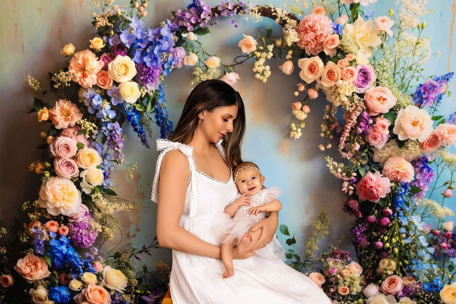 Portrait of mom and baby under floral arch at Vancouver studio