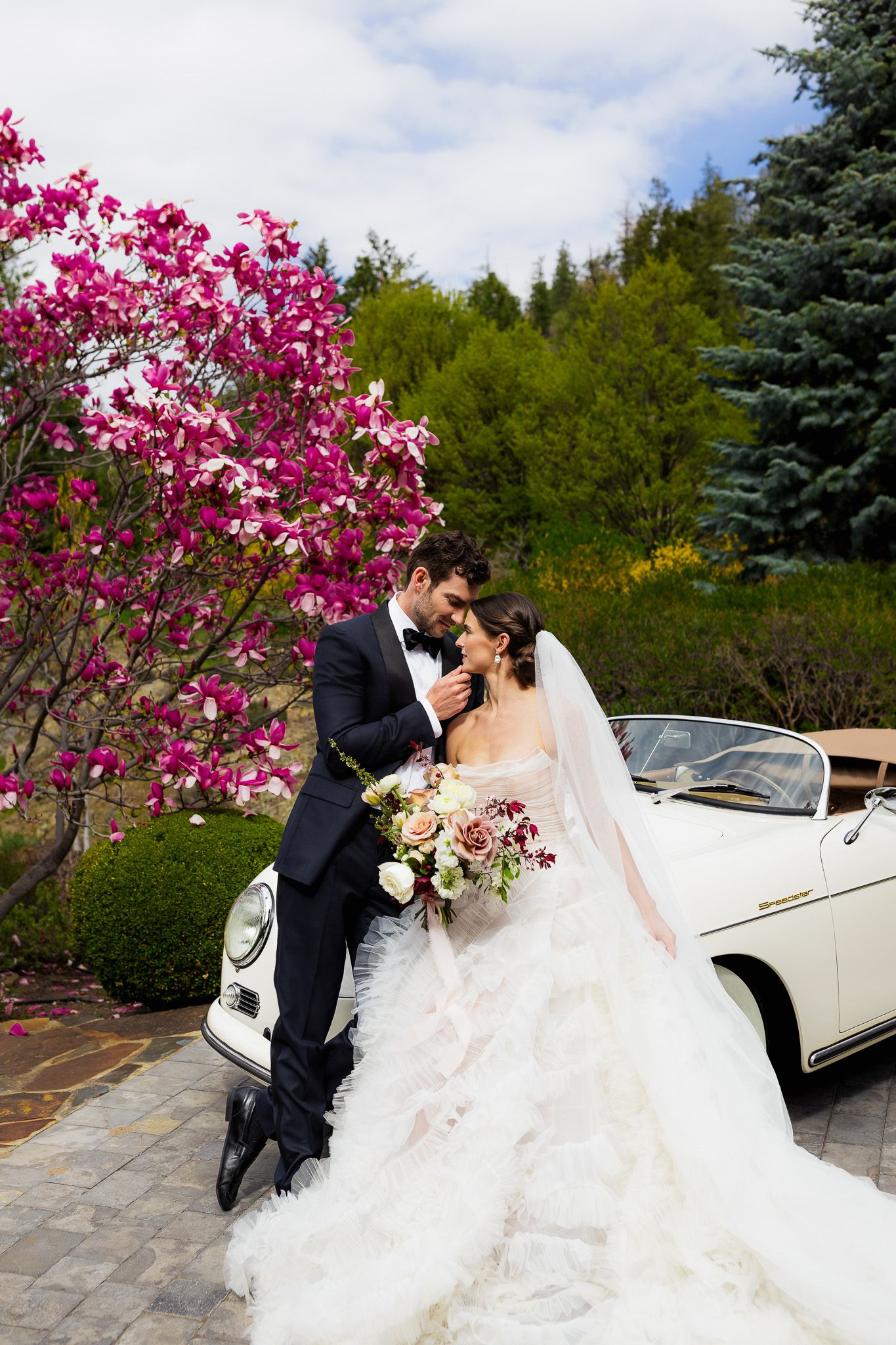 Bride and groom share a joyful moment outside Chateau Okanagan in spring, surrounded by blooming gardens and soft sunlight