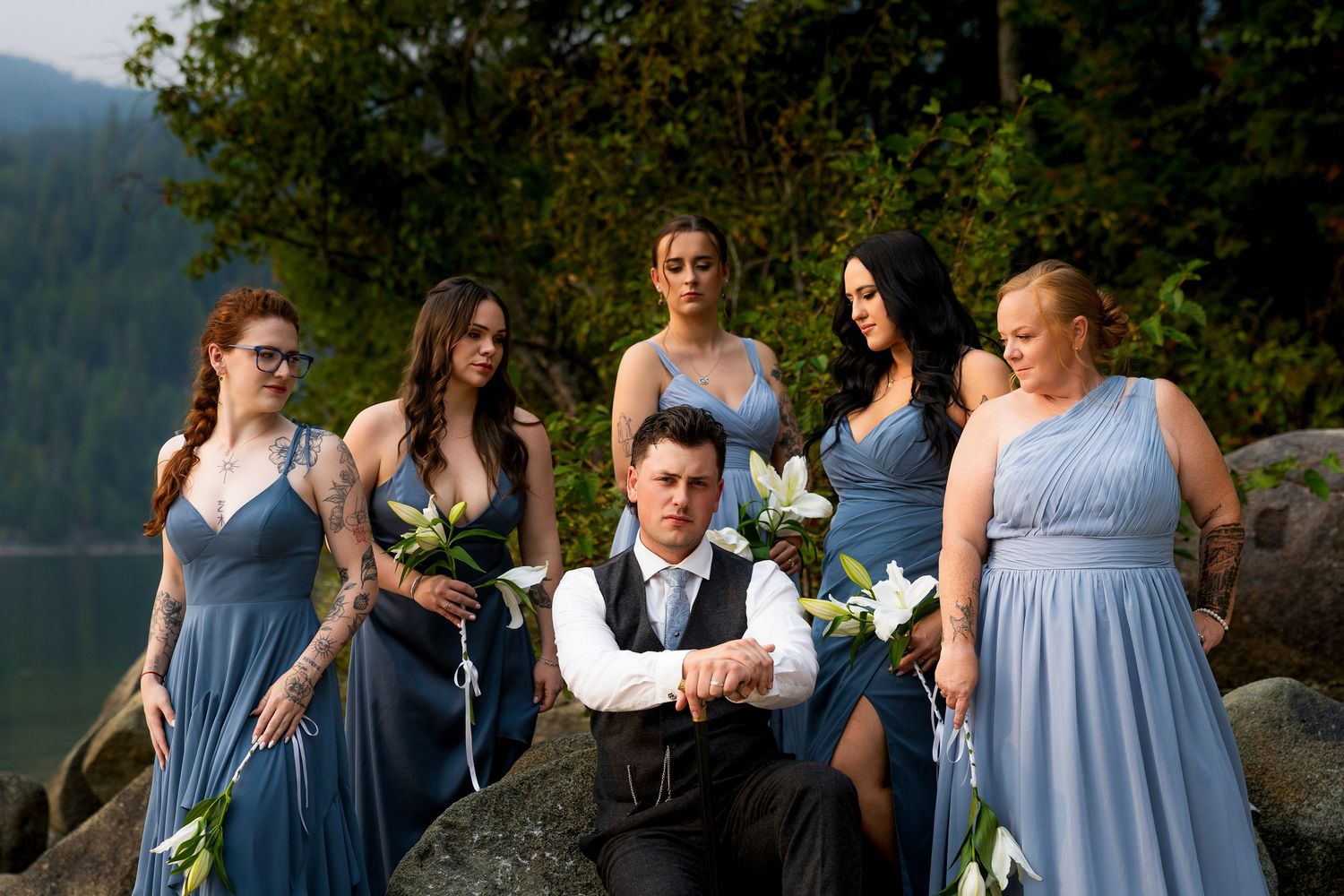 Groom smiling with bridesmaids at a wedding, captured by a professional wedding photographer, showcasing joyful bridal party moments.