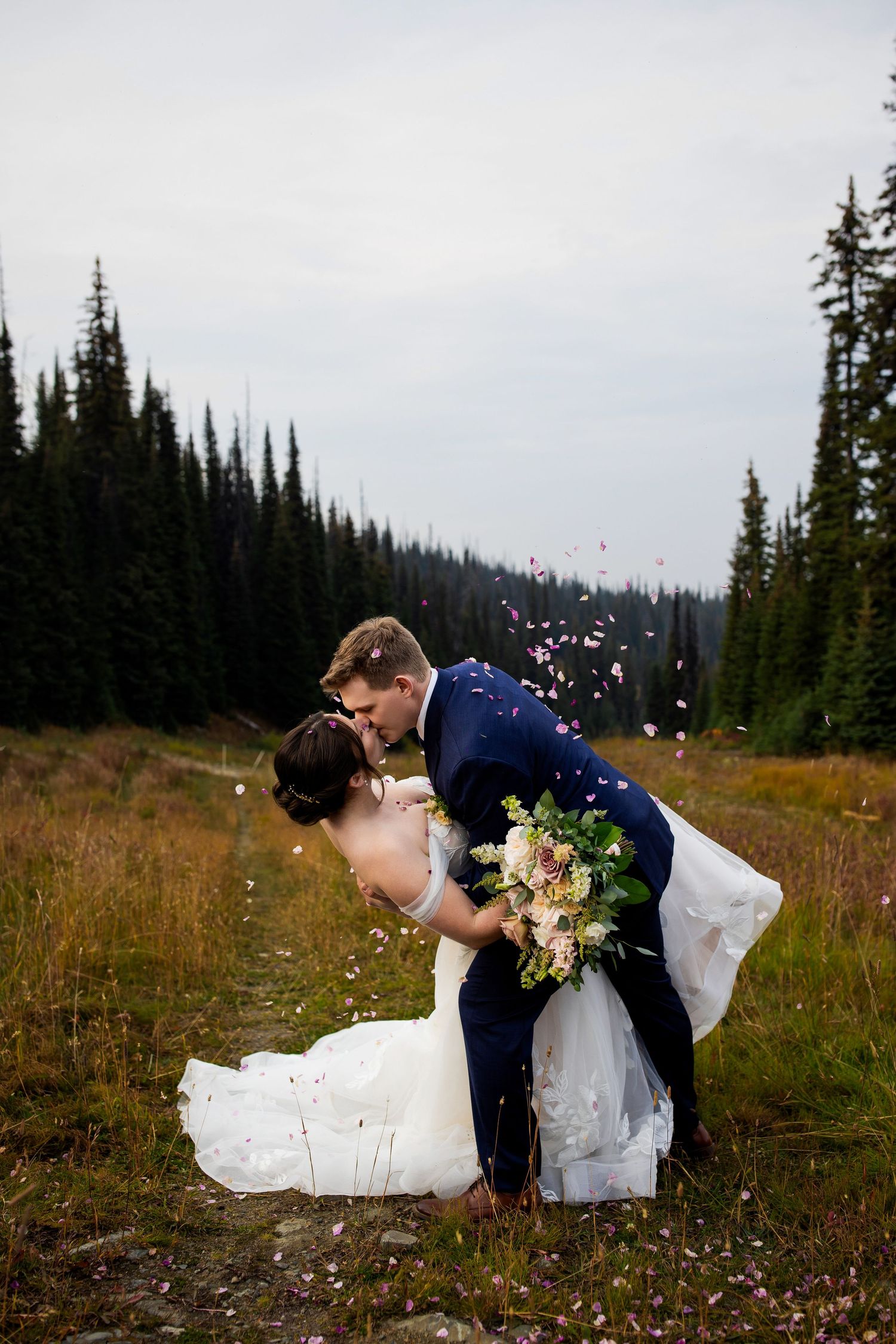 Luxury wedding photo of couple sharing a dip kiss after ceremony at Sun Peaks, capturing romantic and stylish wedding photography.