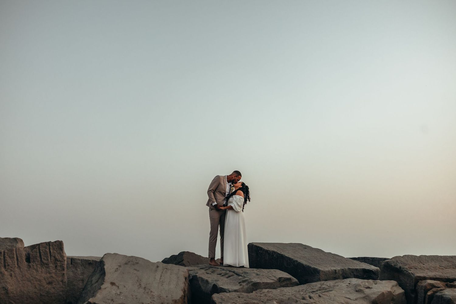 Bride and groom kissing on the beach at sunset, beach elopement photography